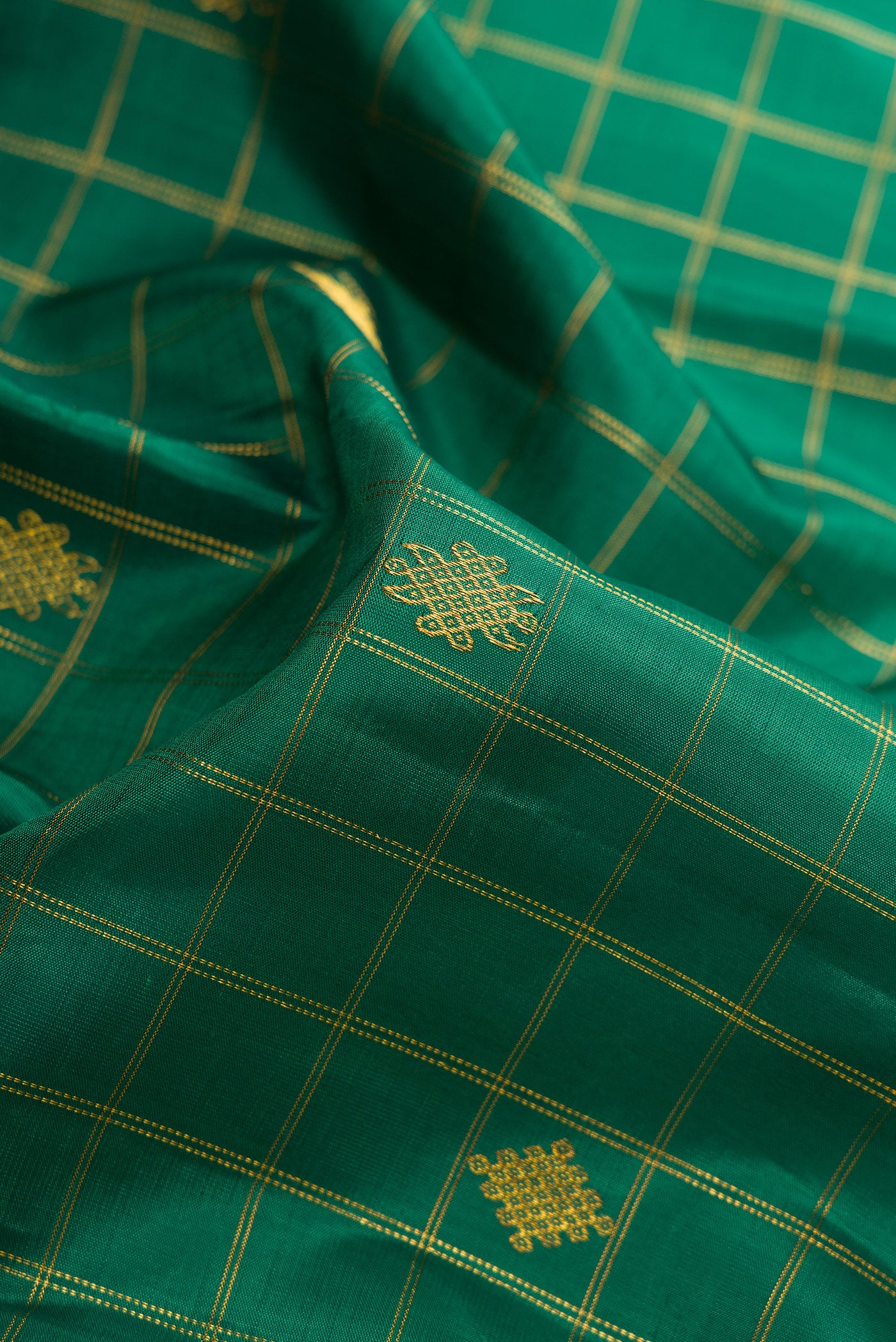 Close up of Green Dual Tone Kanjivaram Silk Saree with Checked design on the body and Zari Border.  displaying folds