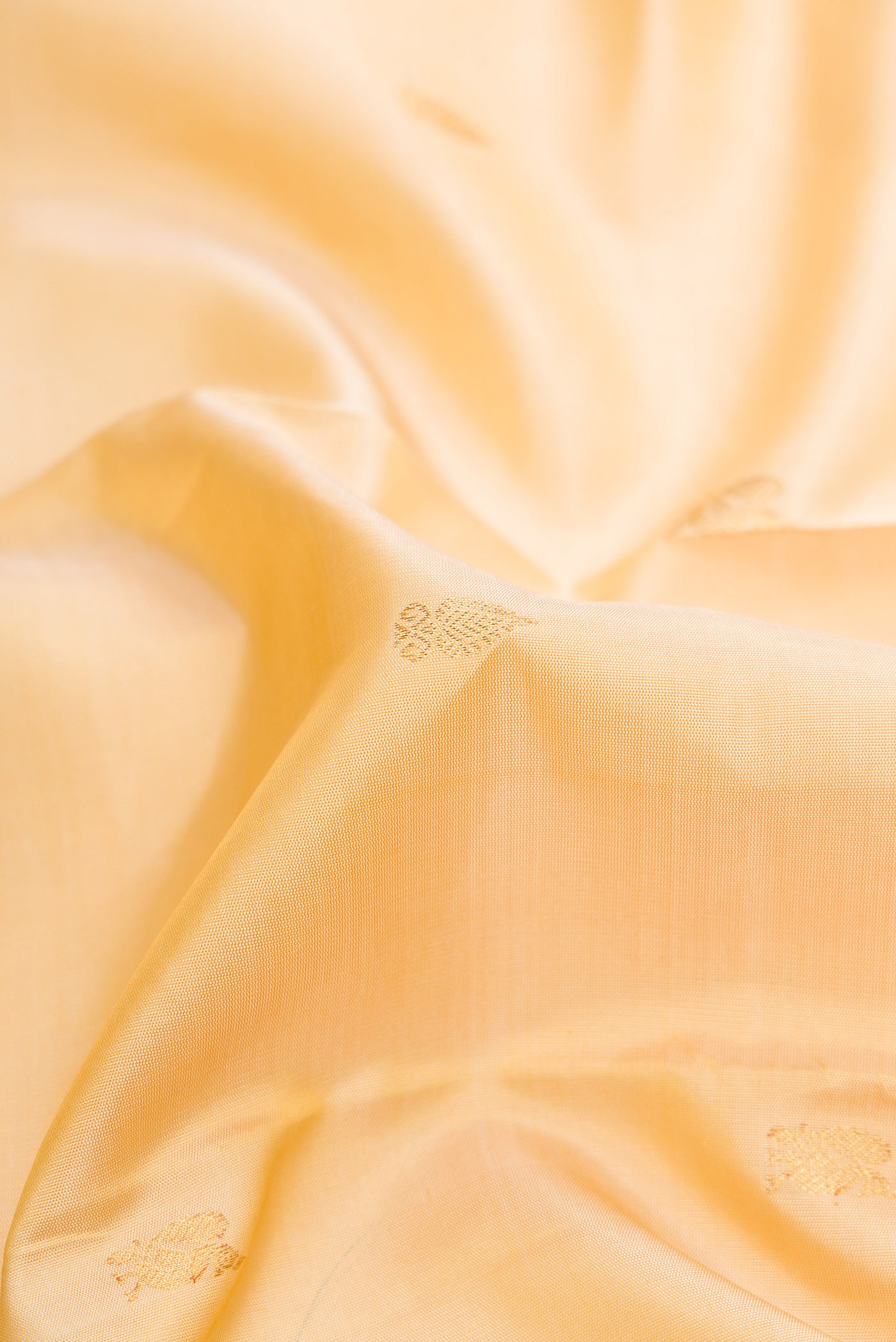 Close up of Pure Silk Pure Zari Sandal Dual Tone Kanchipuram Saree with Zari Butta on the body and Zari Border.  displaying folds