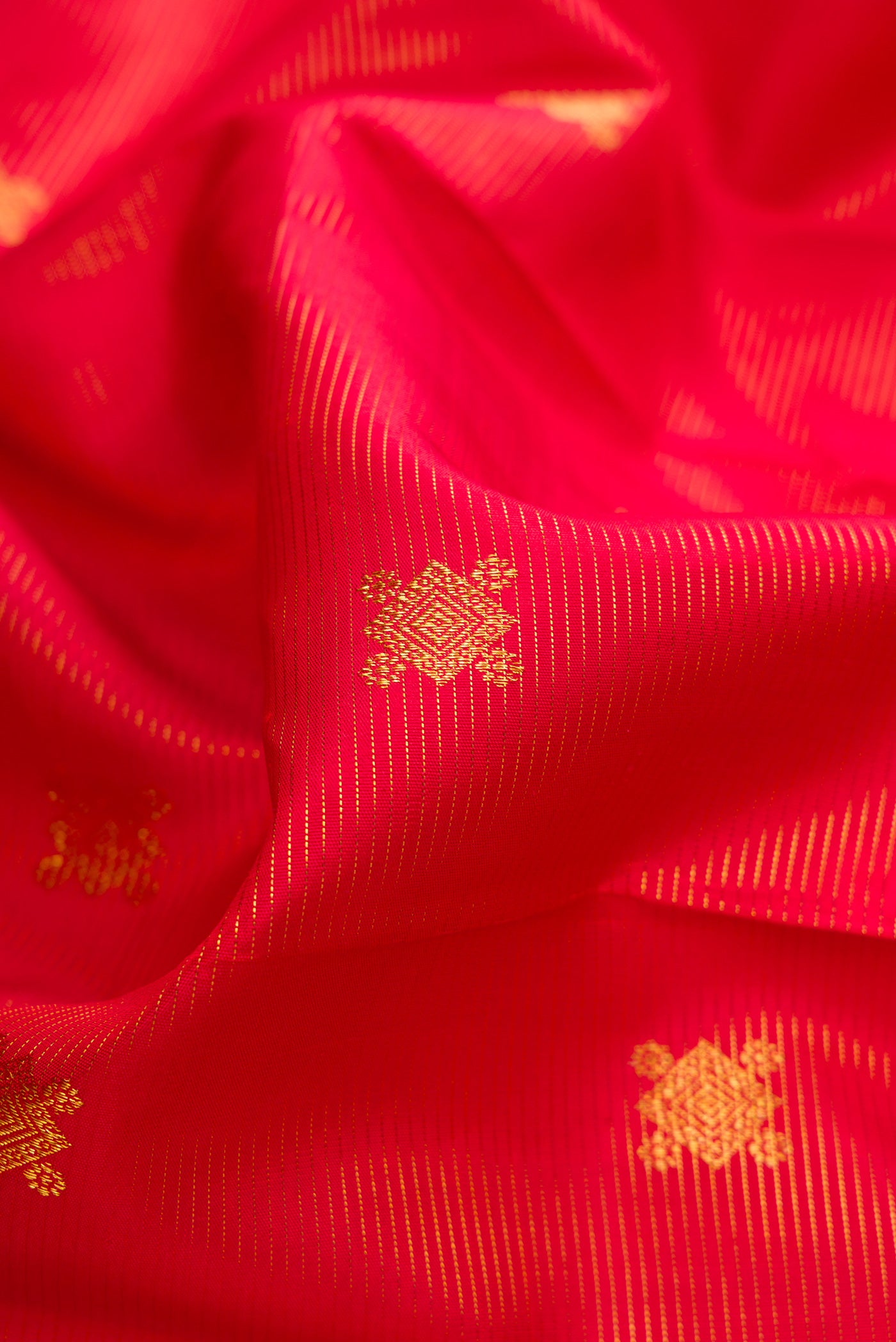 Close up of Pure Silk Pure Zari Red Dual Tone Kanjivaram Saree with Stripes on the body and Zari Border.  displaying folds