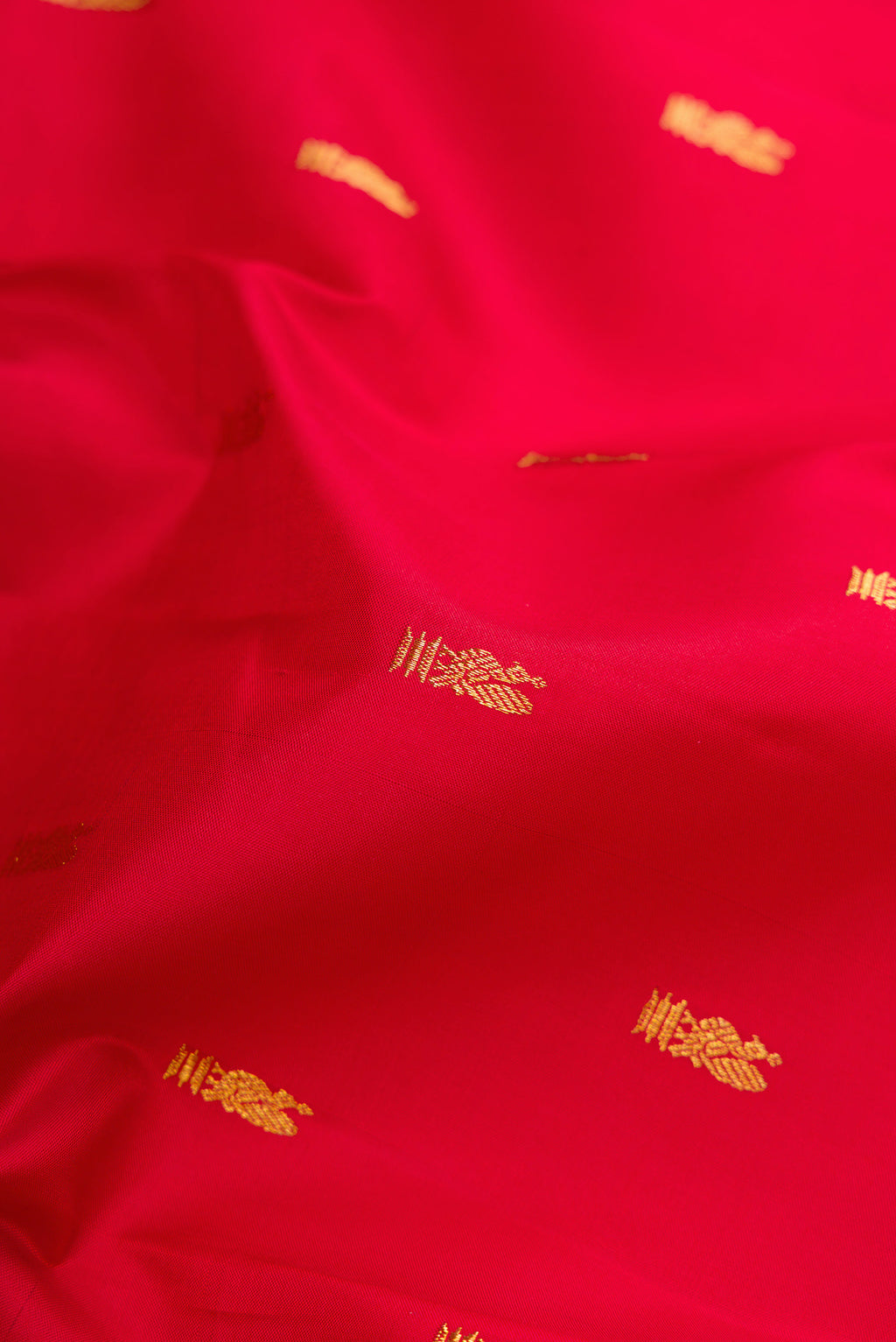 Close up of Red Kanjivaram Silk Saree with Zari Butta on the body and Zari Border.  displaying folds