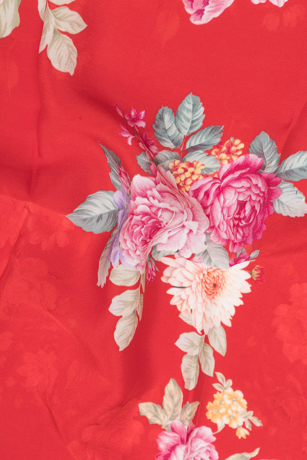 Close up of Red Crepe Saree with Floral Print on the body and Zari Border.  displaying folds