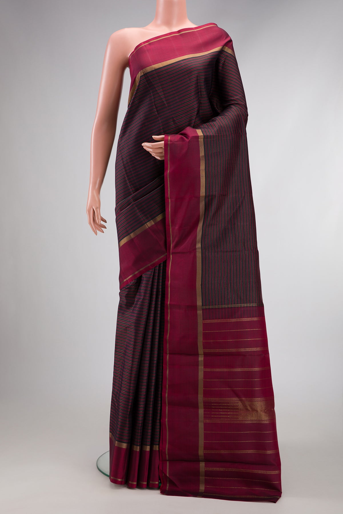 Pure Silk Pure Zari Burgundy Dual Tone Kanchipuram Saree with Stripes on the body and Zari Border.  displayed on a mannequin
