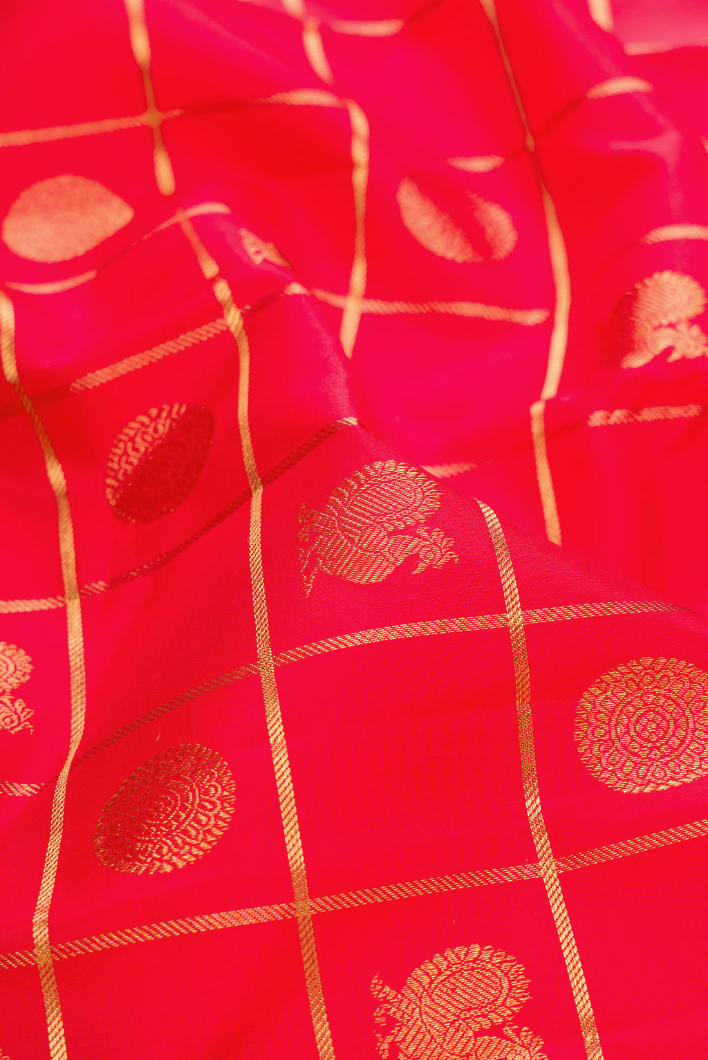 Close up of Pure Silk Pure Zari Red Dual Tone Kanjivaram Saree with Checked design on the body and Zari Border.  displaying folds