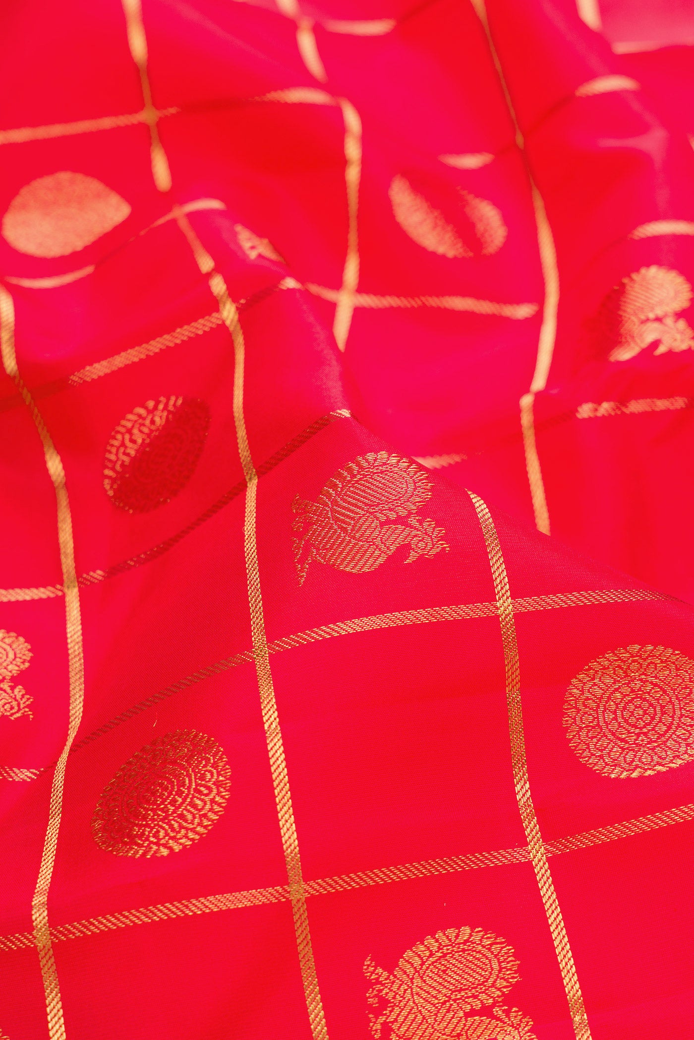 Close up of Pure Silk Pure Zari Red Dual Tone Kanjivaram Saree with Checked design on the body and Zari Border.  displaying folds