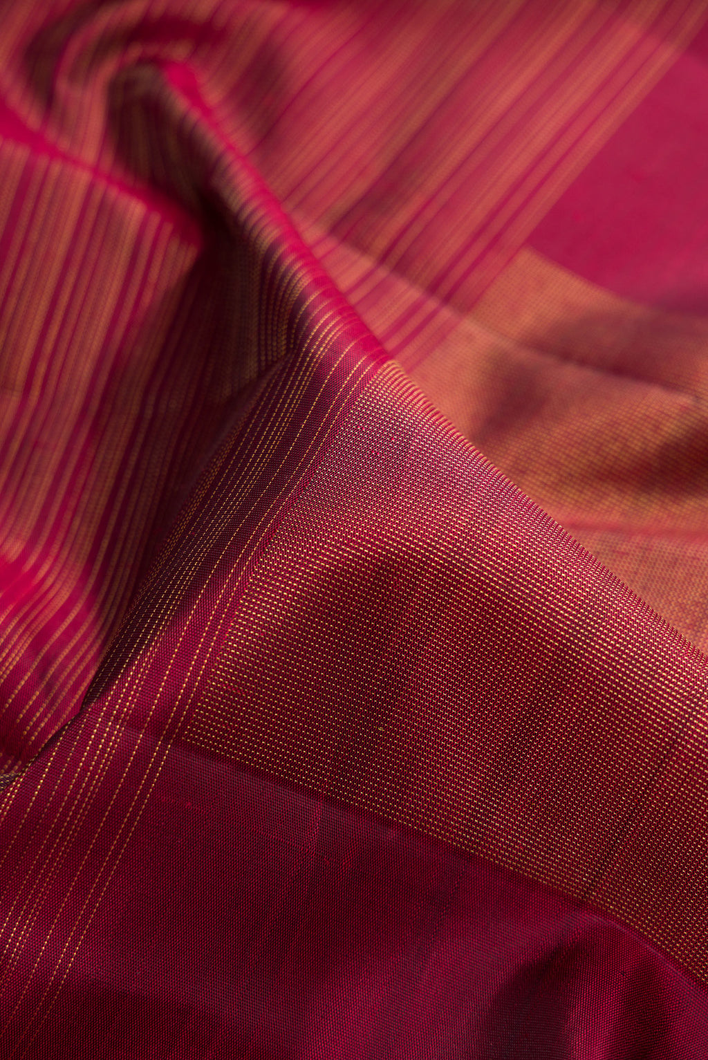 Close up of Pure Silk Pure Zari Burgundy Dual Tone Kanchipuram Saree with Stripes on the body and Without Border.  displaying folds