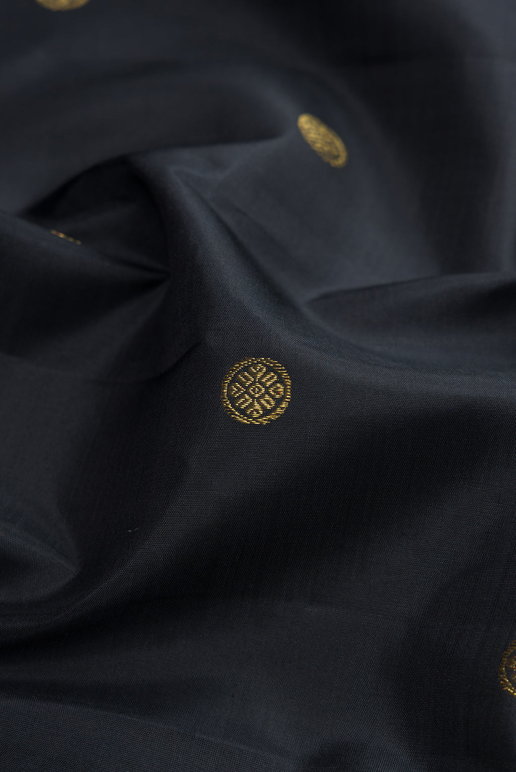 Close up of Black Kanchipuram Silk Saree with Zari Butta on the body and Checks Border.  displaying folds