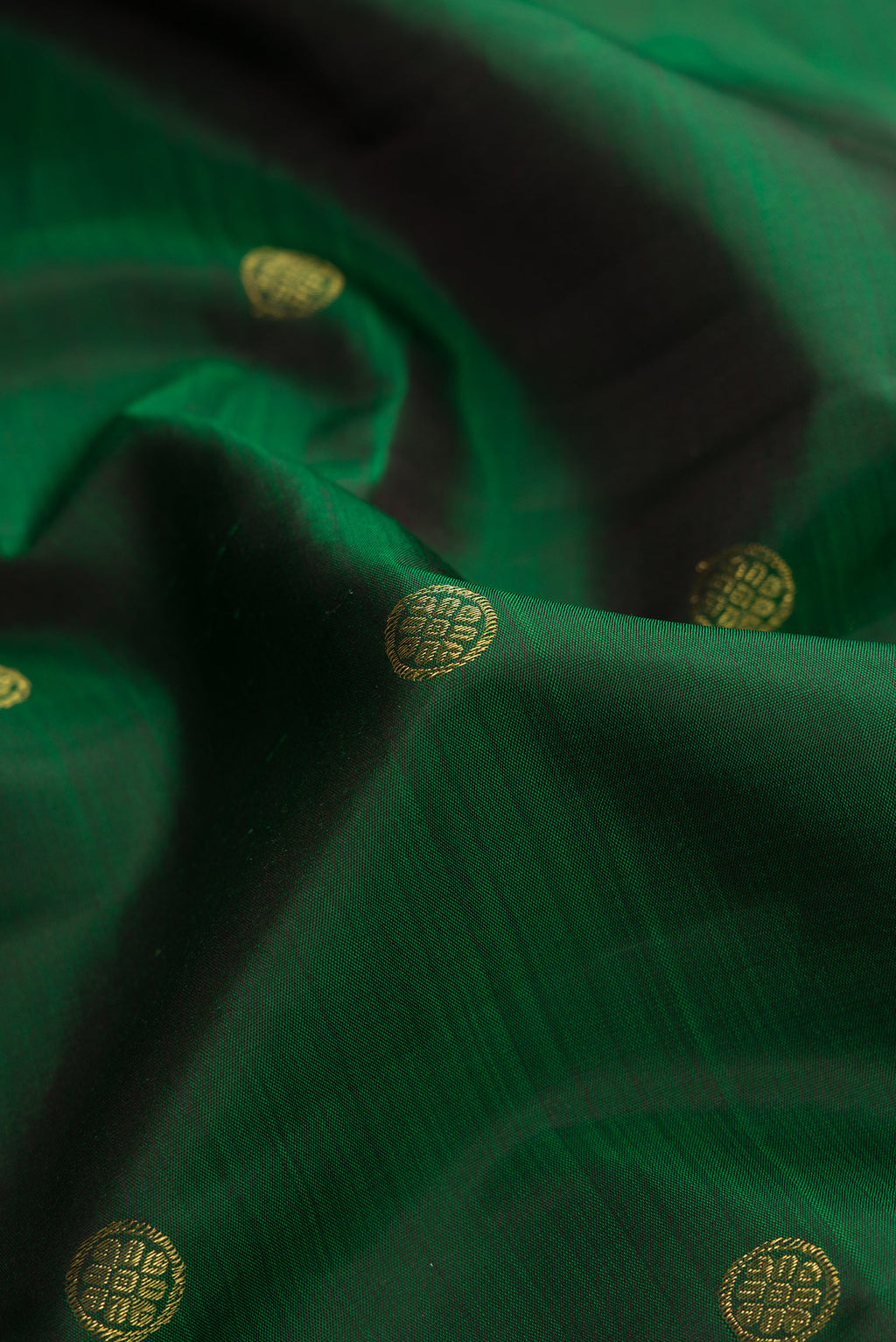 Close up of Pure Silk Pure Zari Green Dual Tone Kanchipuram Saree with Zari Butta on the body and Zari Border.  displaying folds