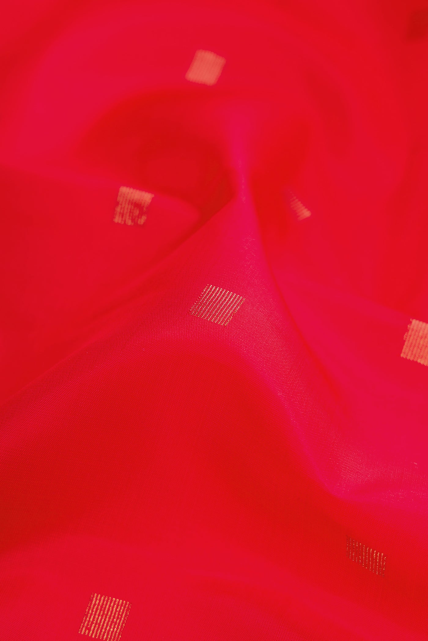 Close up of Pure Silk Pure Zari Red Dual Tone Kanchipuram Saree with Zari Butta on the body and Without Border.  displaying folds