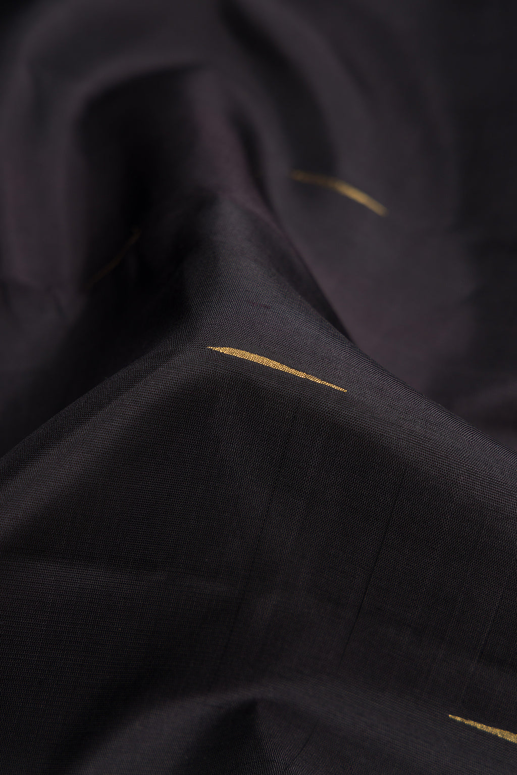 Close up of Pure Silk Pure Zari Black Dual Tone Kanjivaram Saree with Zari Butta on the body and Zari Border.  displaying folds