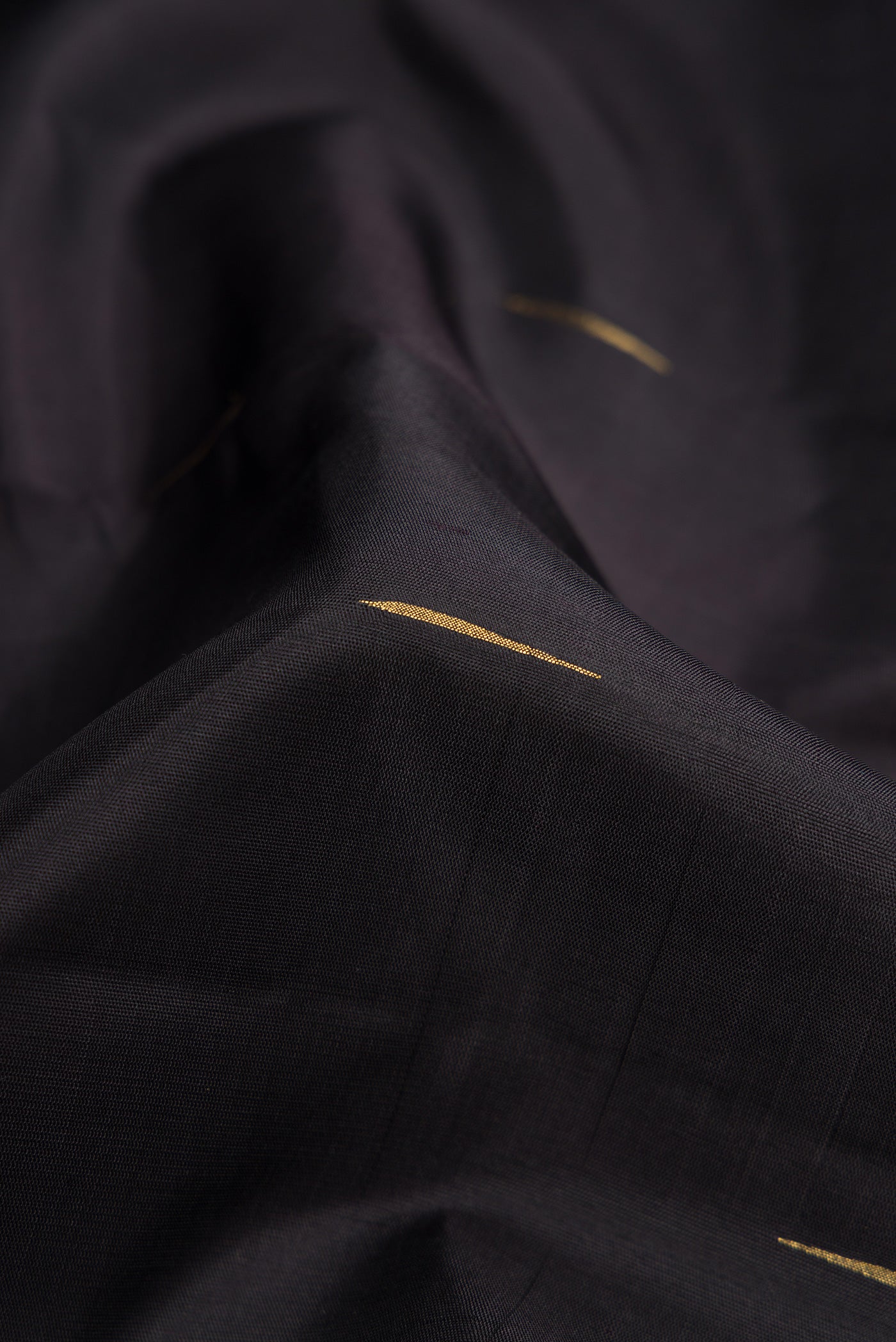 Close up of Pure Silk Pure Zari Black Dual Tone Kanjivaram Saree with Zari Butta on the body and Zari Border.  displaying folds