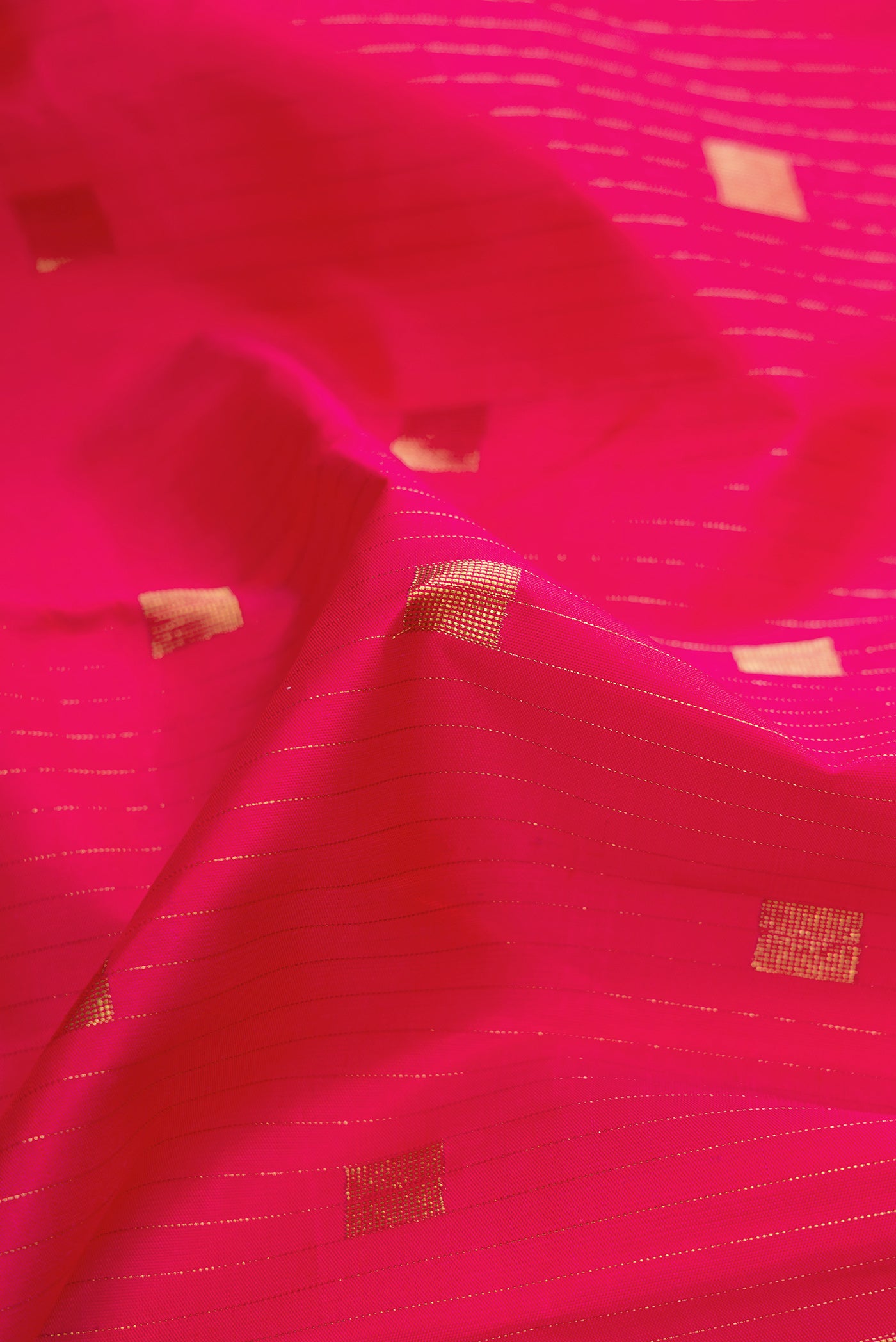 Close up of Pure Silk Pure Zari Pink Dual Tone Kanchipuram Saree with Zari Butta on the body and Without Border.  displaying folds