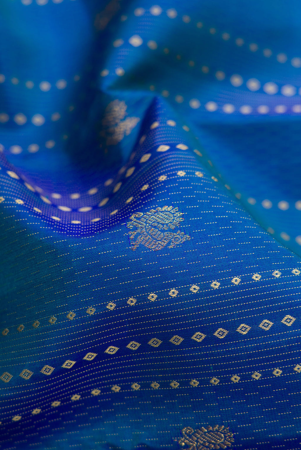 Close up of Peacock Blue Dual Tone Kanchipuram Silk Saree with Stripes on the body and Without Border.  displaying folds