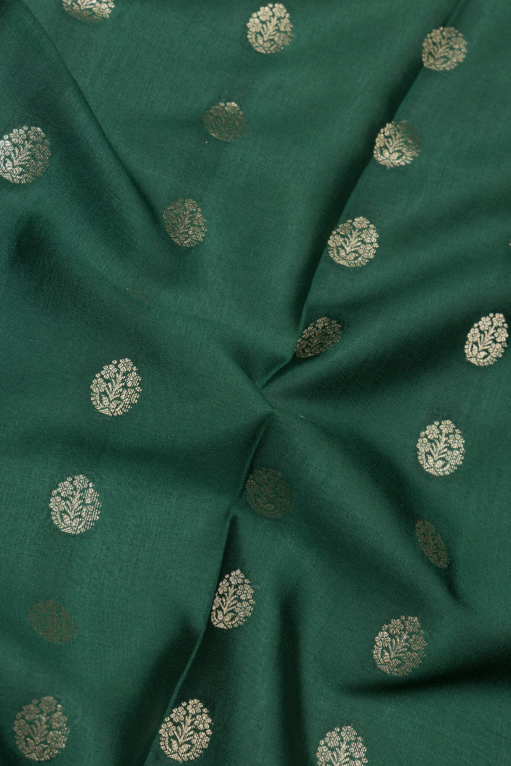Close up of Bottle Green Mysore Silk Saree with Zari Butta on the body and Zari Border.  displaying folds