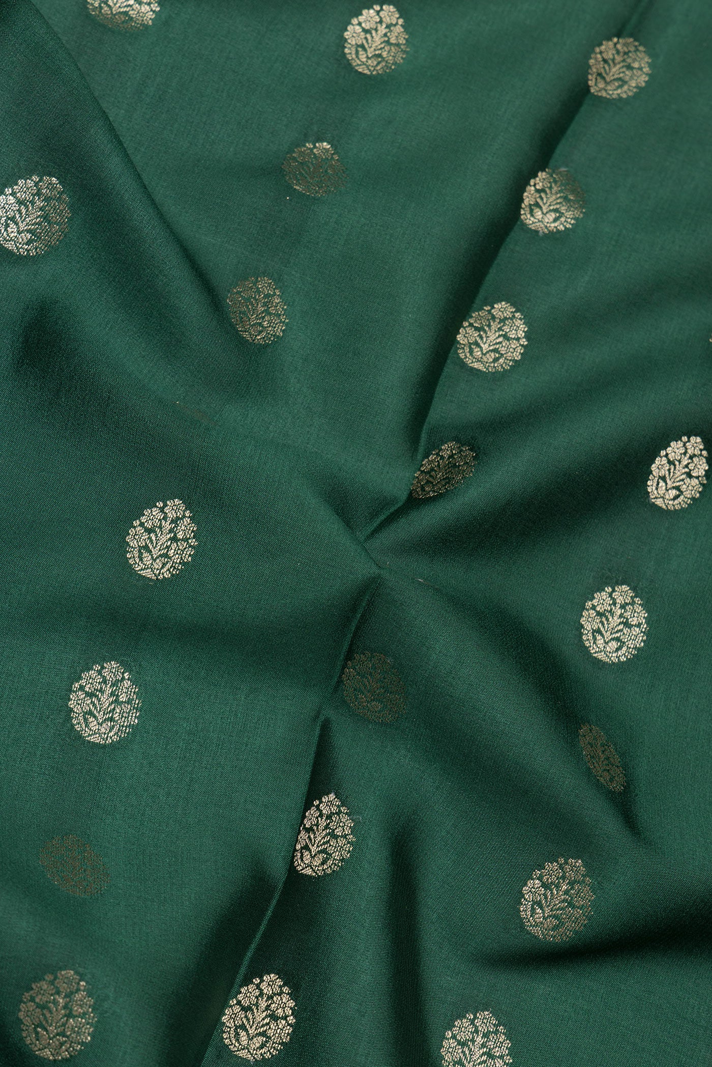 Close up of Bottle Green Mysore Silk Saree with Zari Butta on the body and Zari Border.  displaying folds