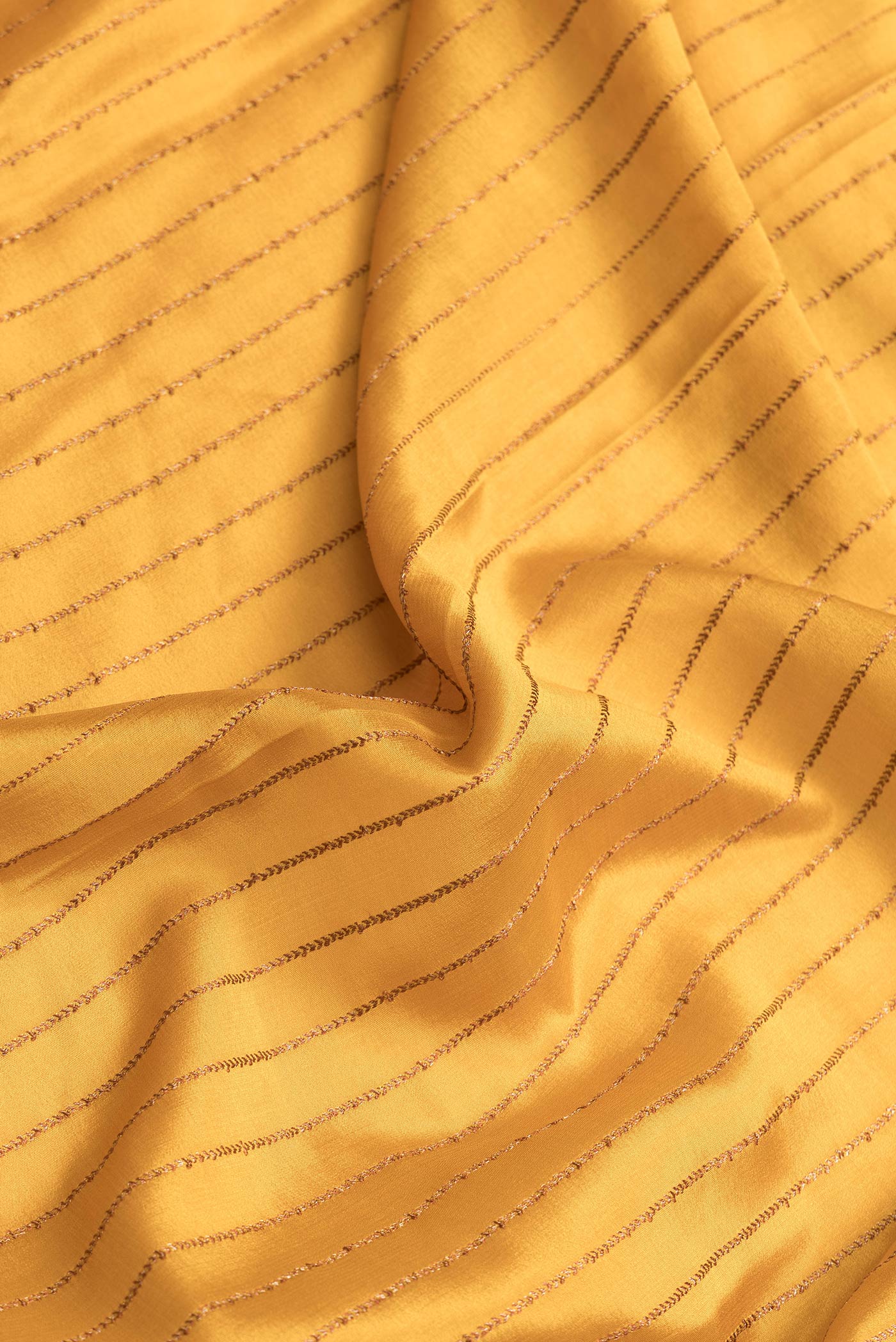 Close up of Mustard Dual Tone Mysore Silk Saree with Stripes on the body and Fancy Border.  displaying folds