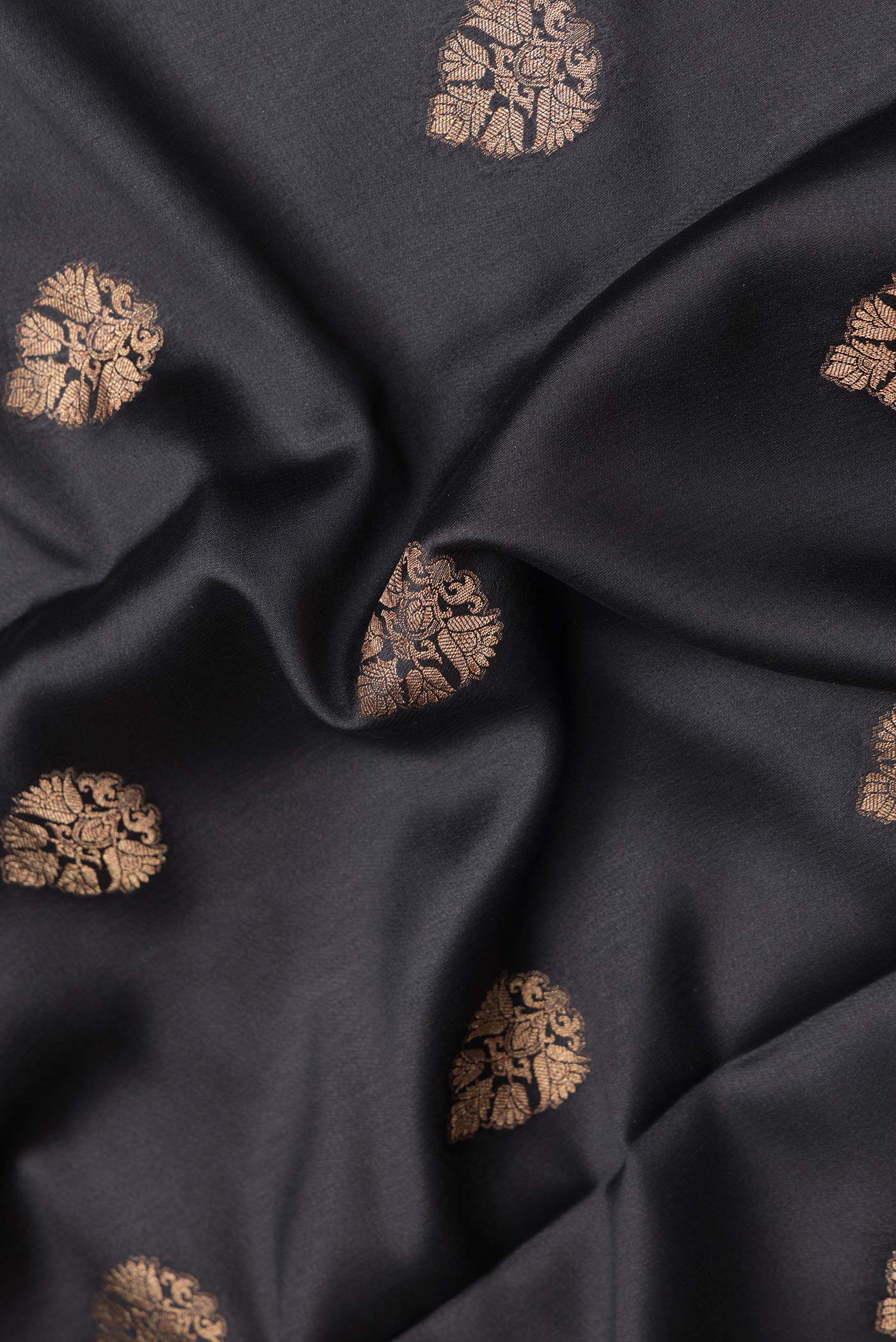 Close up of Black Dual Tone Mysore Silk Saree with Zari Butta on the body and Zari Border.  displaying folds