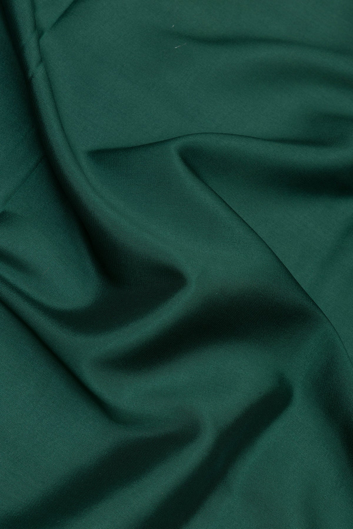 Close up of Bottle Green Mysore Silk Saree with Plain Body and Zari Border.  displaying folds