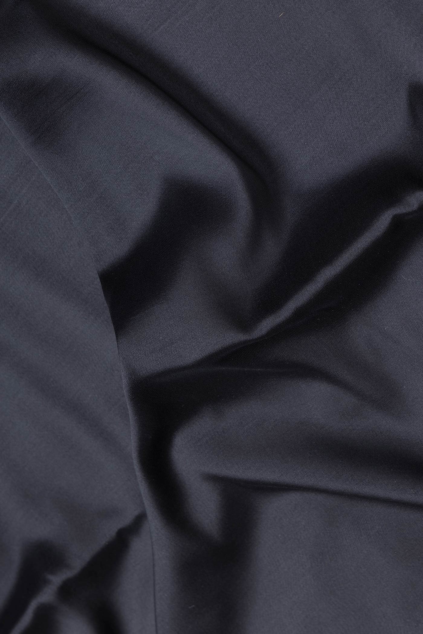 Close up of Black Dual Tone Mysore Silk Saree with Zari Butta on the body and Zari Border.  displaying folds