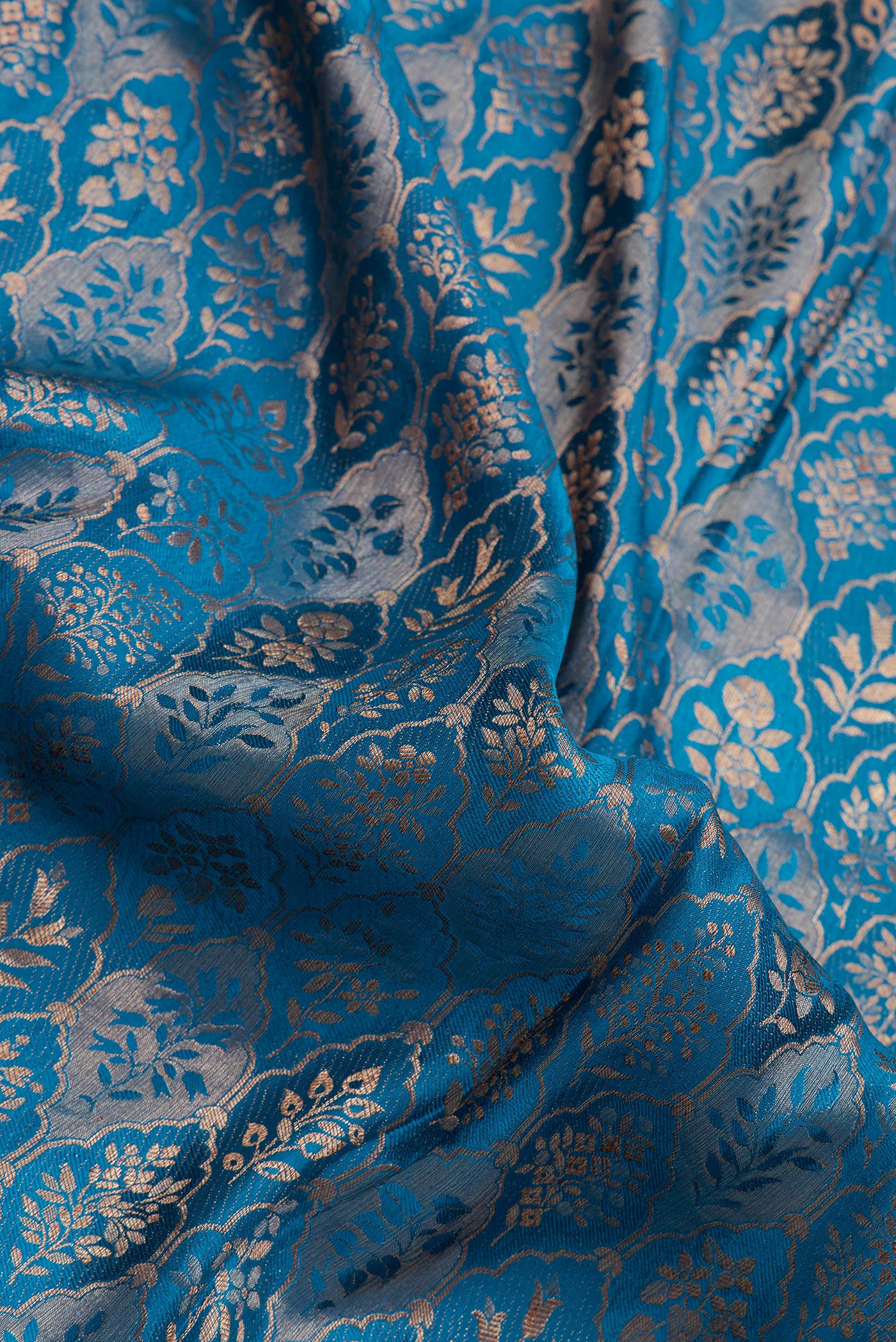Close up of Peacock Blue Mysore Crepe Saree with Zari Brocade on the body and Zari Border.  displaying folds