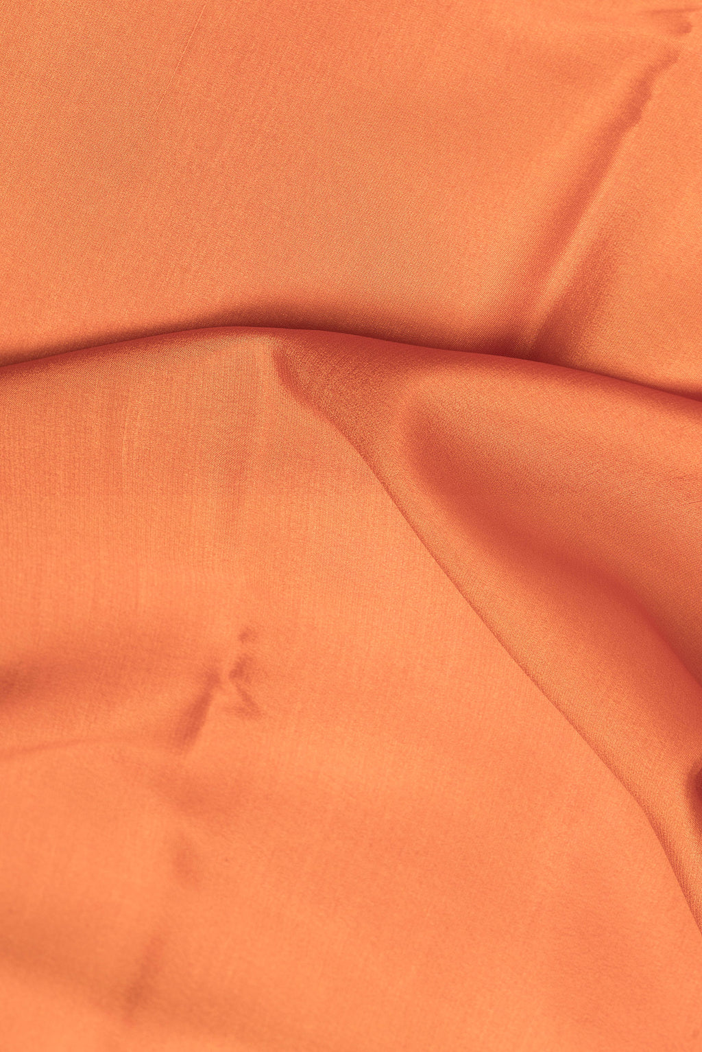 Close up of Brick Orange Mysore Crepe Saree with Plain Body and Zari Border.  displaying folds