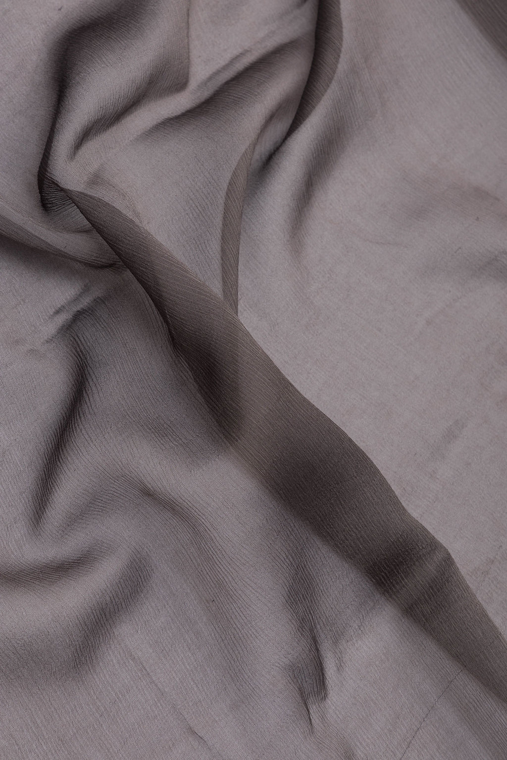 Close up of Grey Mysore Chiffon Saree with Plain Body and Zari And Thread Border.  displaying folds