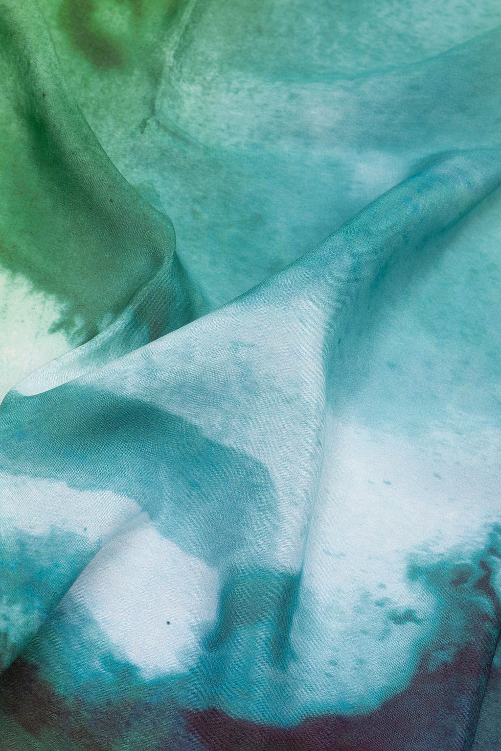 Close up of Green Crepe Saree with Printed design on the body and Plain Border.  displaying folds
