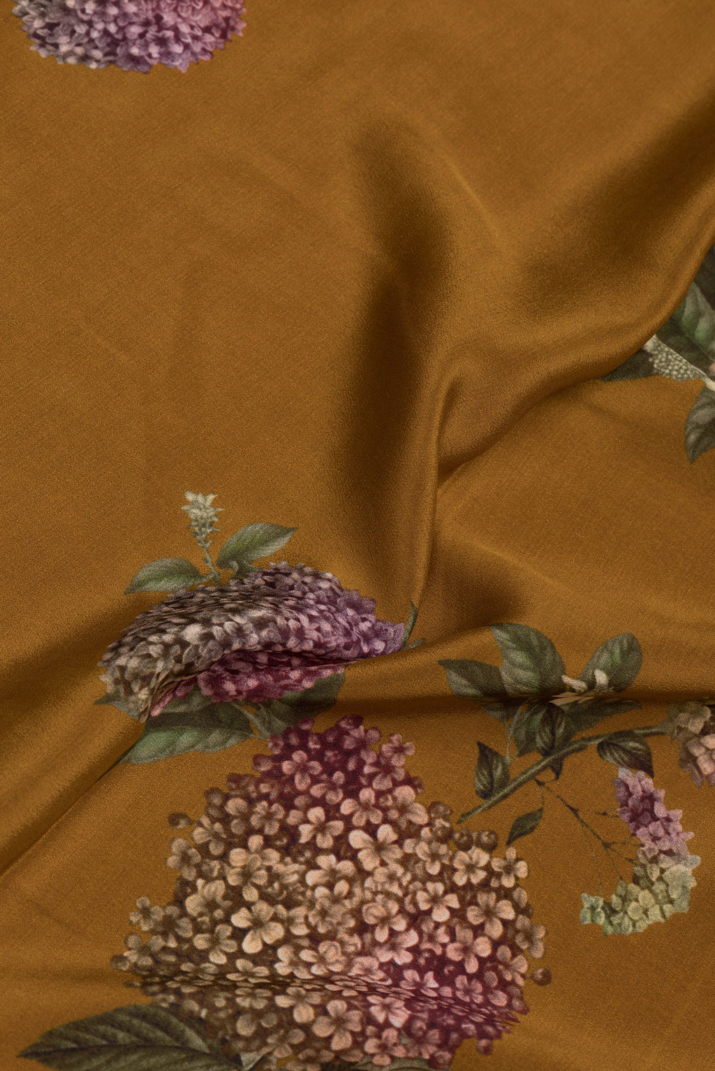Close up of Mustard Dual Tone Crepe Saree with Printed design on the body and Without Border.  displaying folds