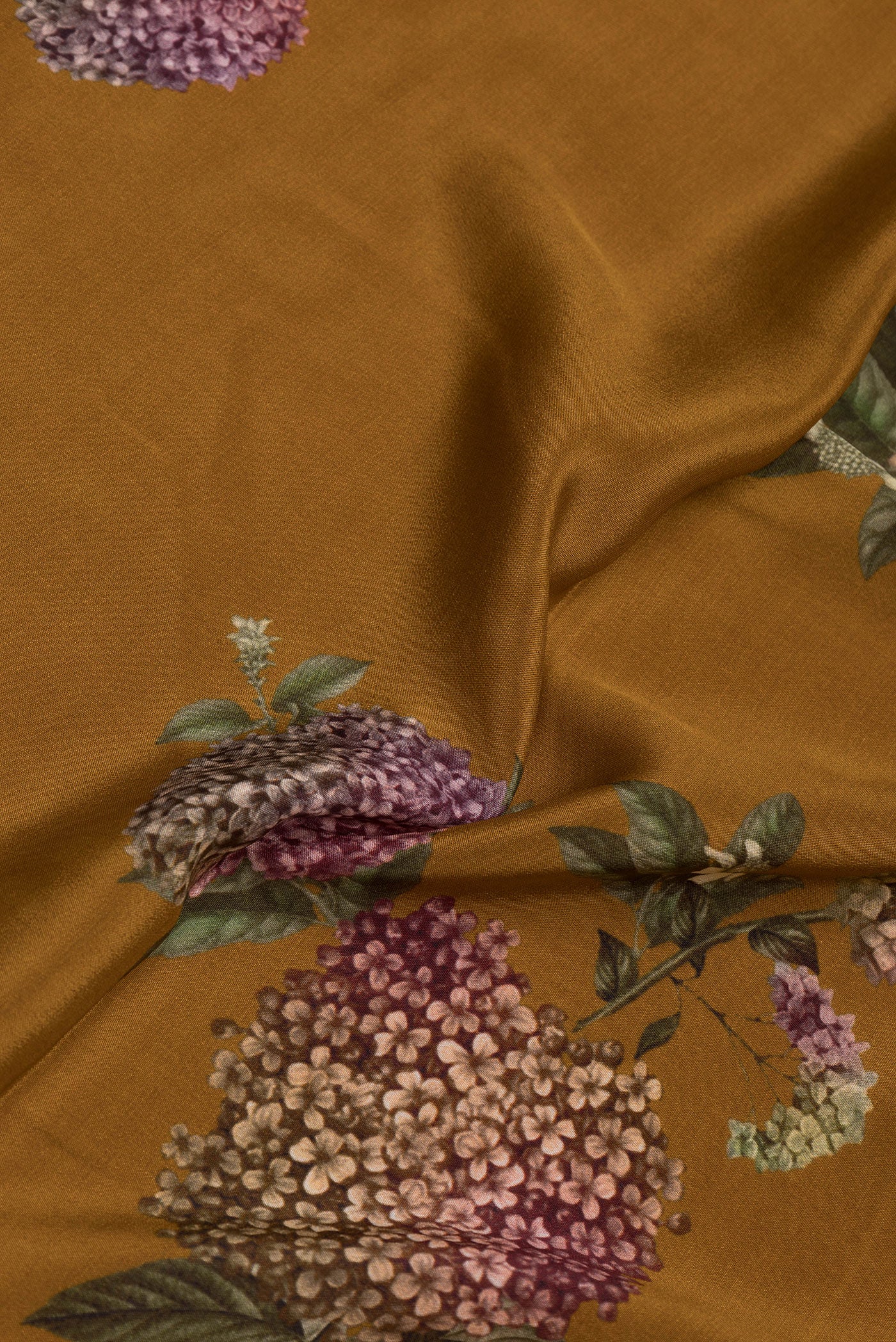Close up of Mustard Dual Tone Crepe Saree with Printed design on the body and Without Border.  displaying folds