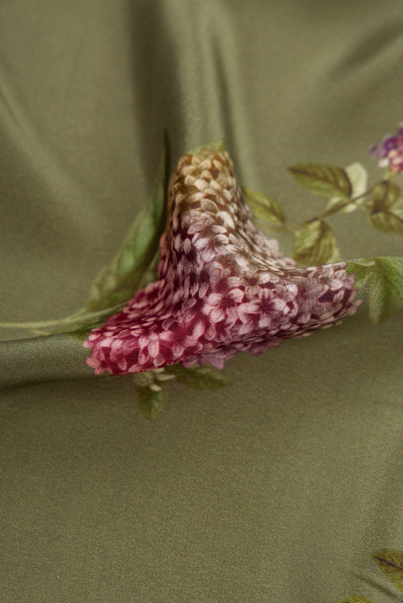 Close up of Green Dual Tone Mysore Crepe Saree with Printed design on the body and Plain Border.  displaying folds