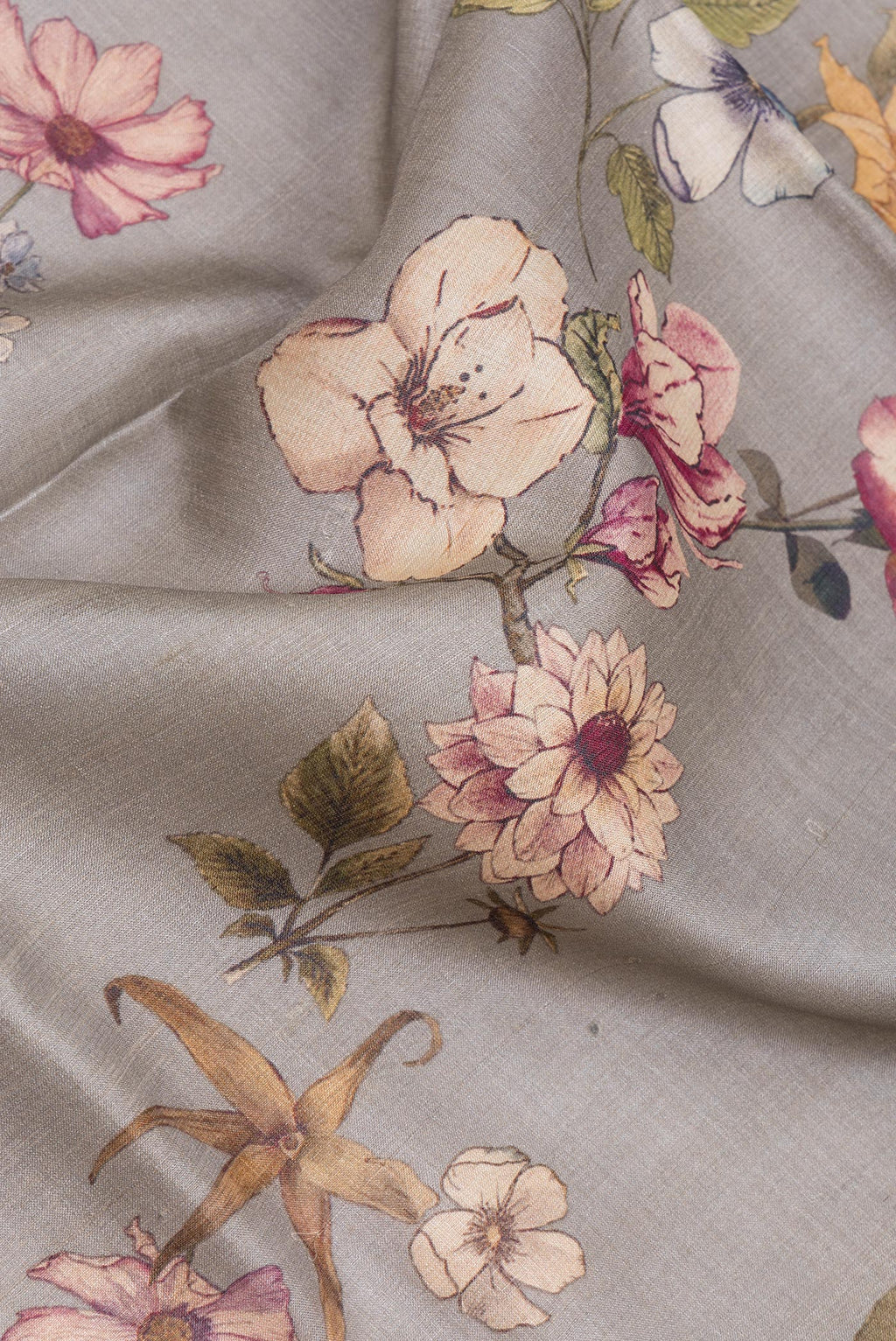Close up of Grey Tussar Silk Saree with Floral Print on the body and Zari Border.  displaying folds