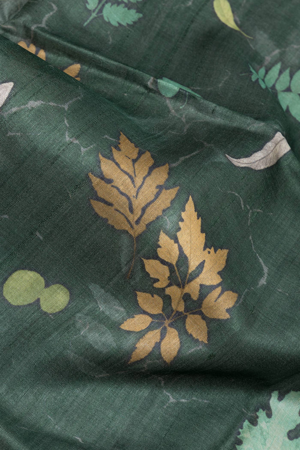 Close up of Bottle Green Tussar Silk Saree with Floral Print on the body and Zari Border.  displaying folds