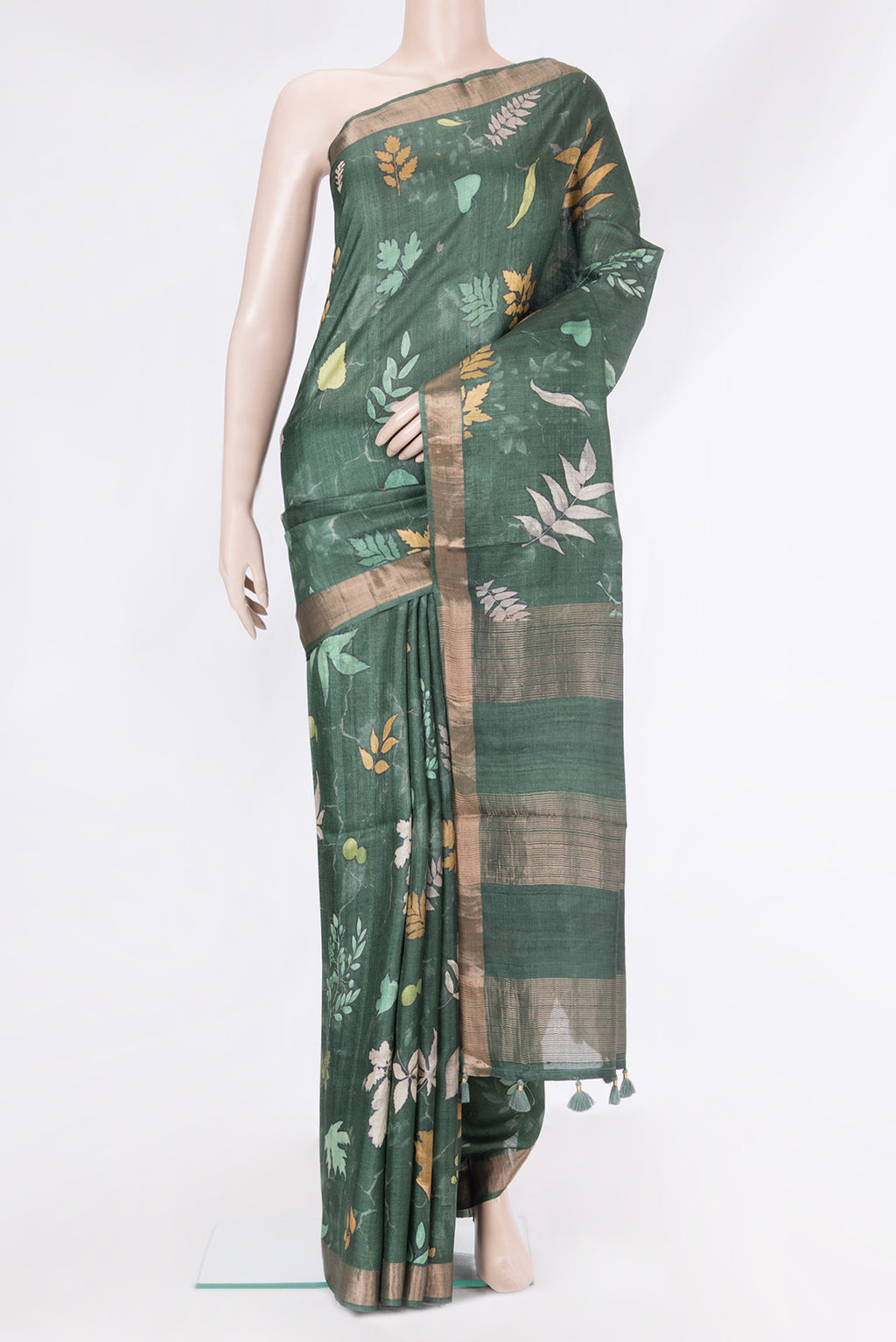 Bottle Green Tussar Silk Saree with Floral Print on the body and Zari Border.  displayed on a mannequin