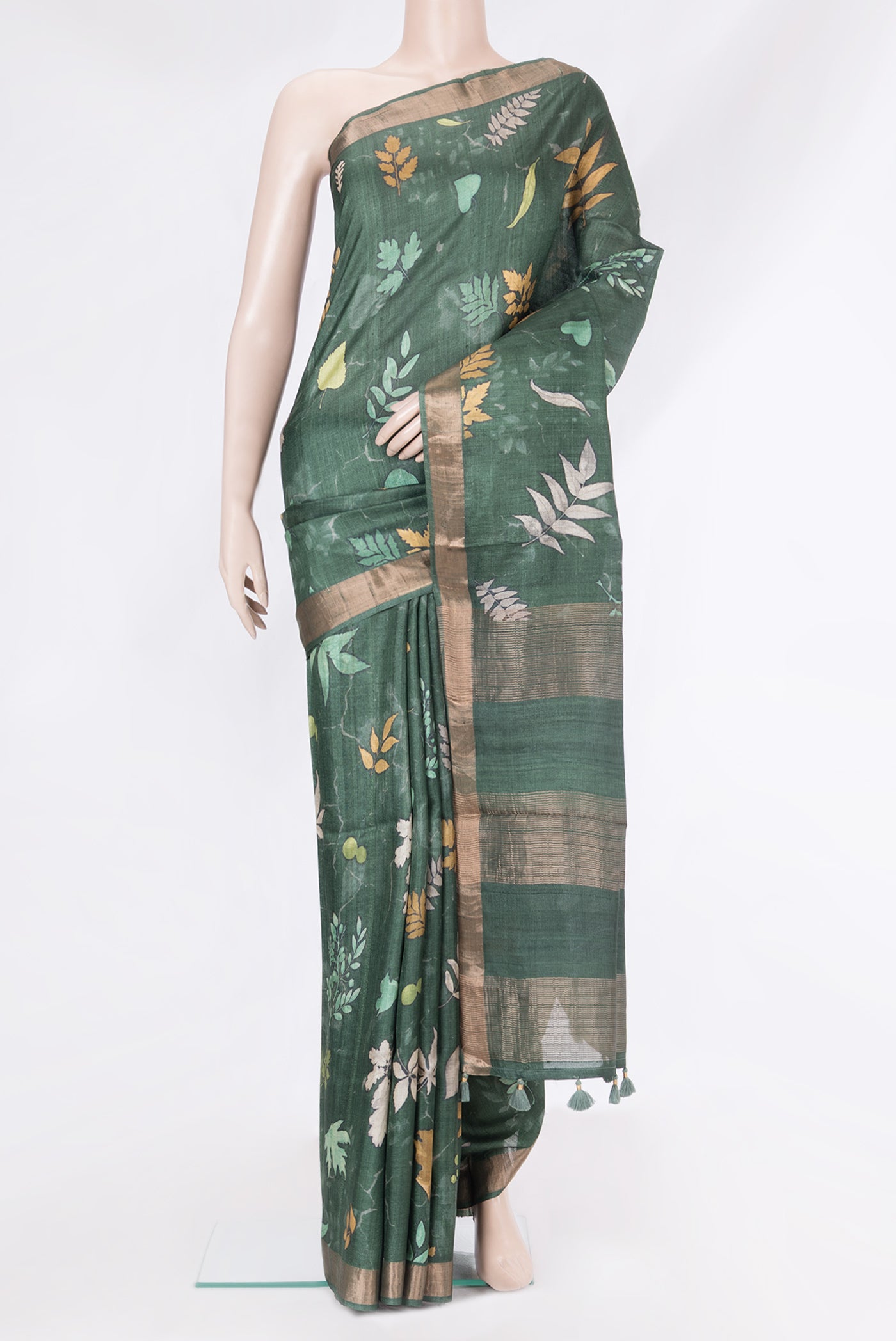 Bottle Green Tussar Silk Saree with Floral Print on the body and Zari Border.  displayed on a mannequin