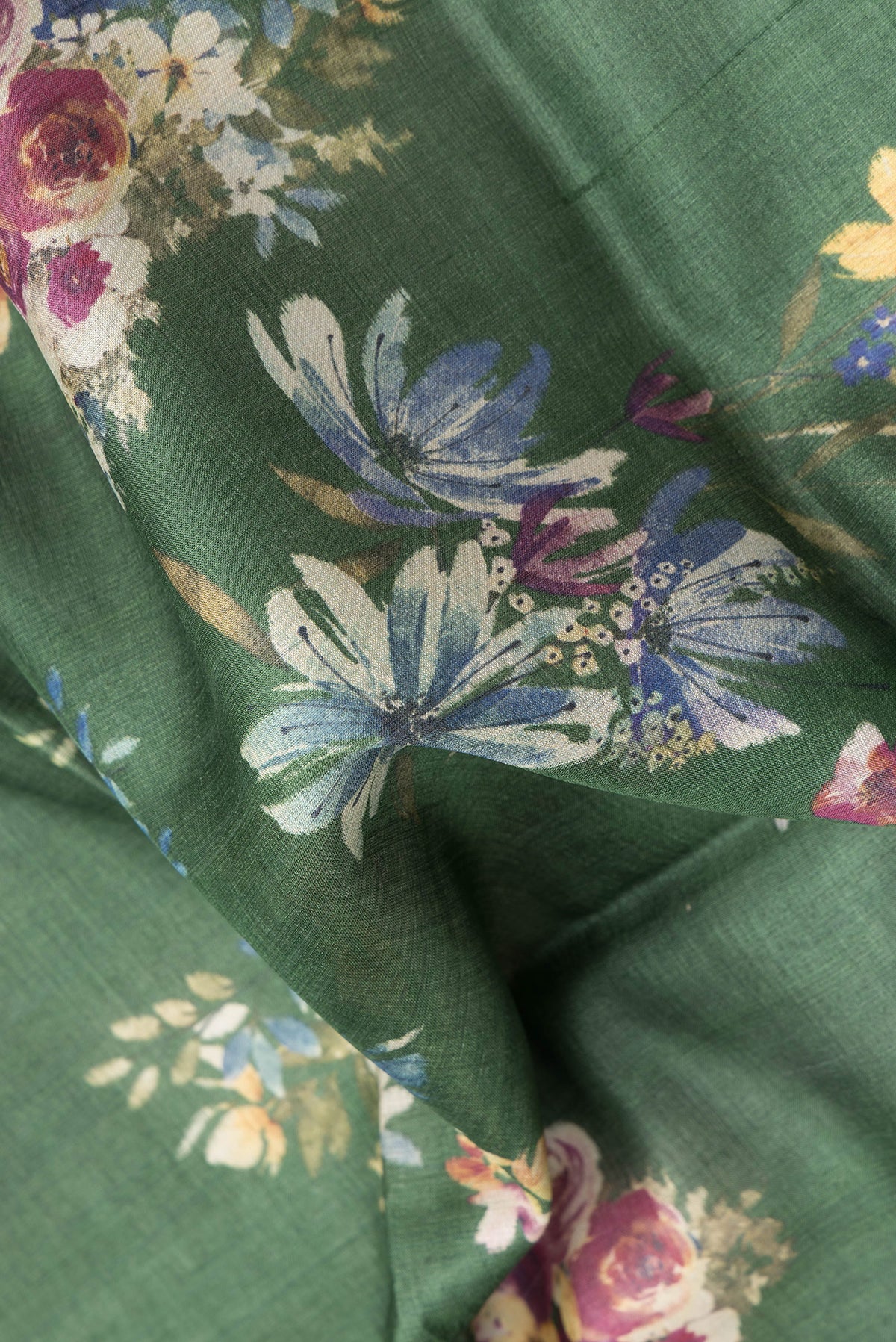 Close up of Olive Green Tussar Silk Saree with Floral Print on the body and Zari Border.  displaying folds
