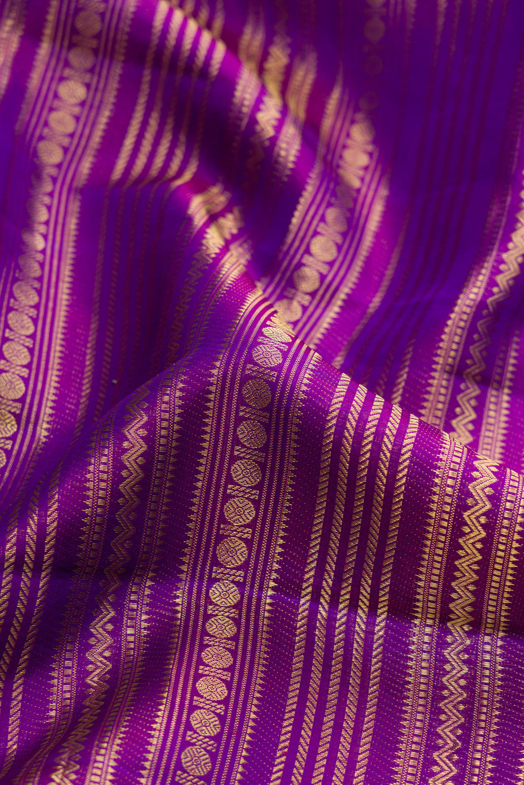 Close up of Purple Dual Tone Kanchipuram Silk Saree with Zari Brocade on the body and Zari Border.  displaying folds