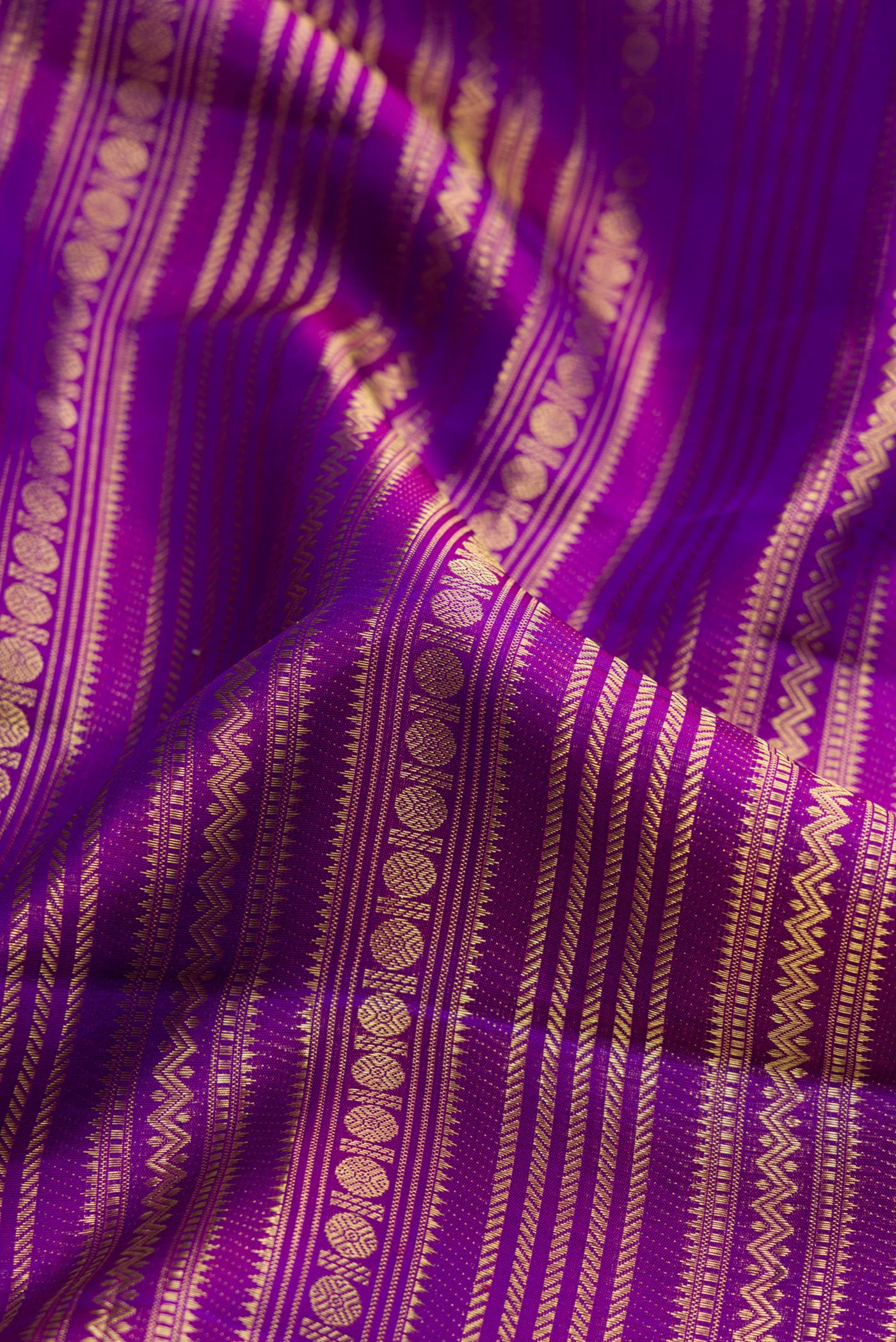 Close up of Purple Dual Tone Kanchipuram Silk Saree with Zari Brocade on the body and Zari Border.  displaying folds
