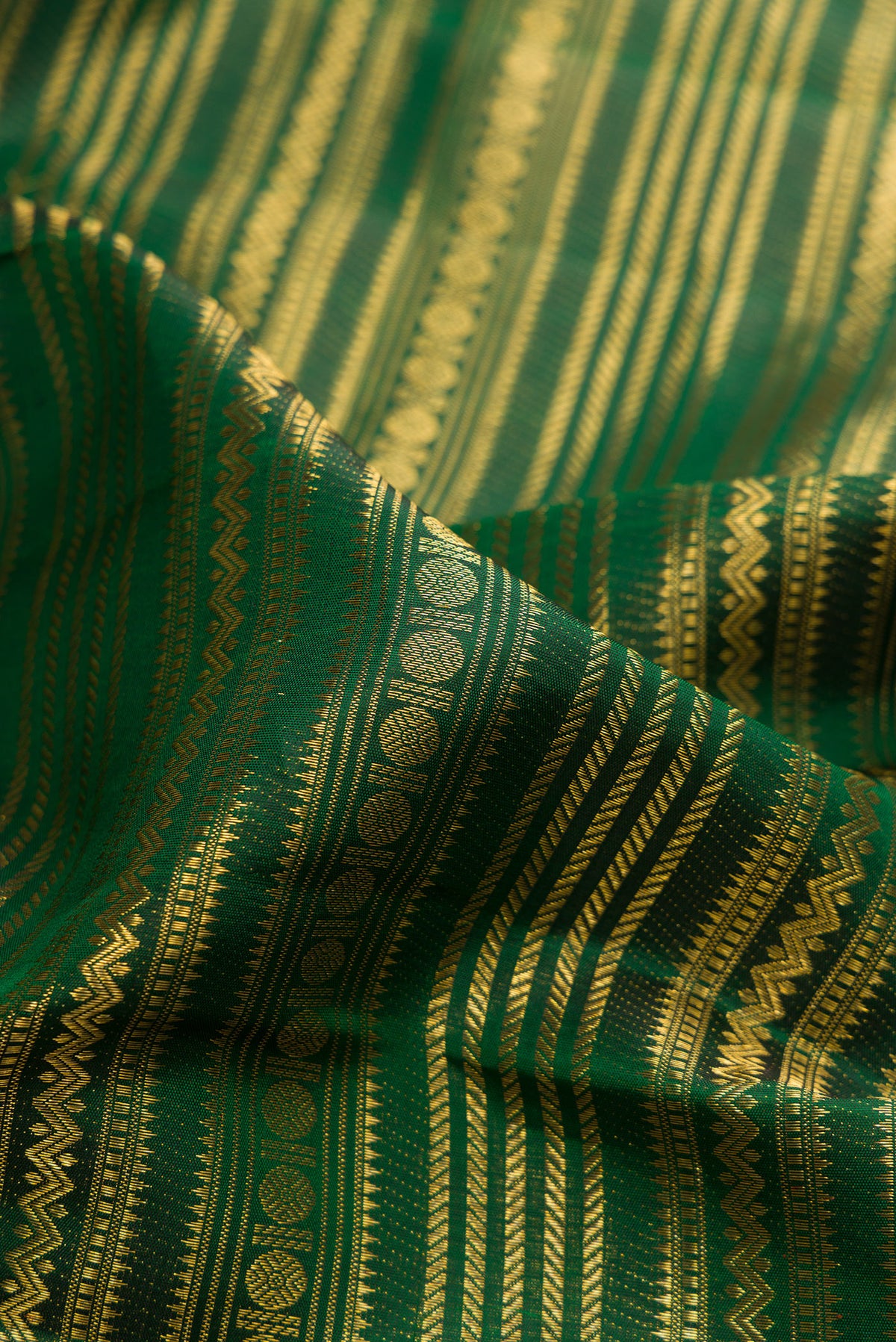 Close up of Pure Silk Bottle Green Kanchipuram Saree with Zari Brocade on the body and Fancy Border.  displaying folds