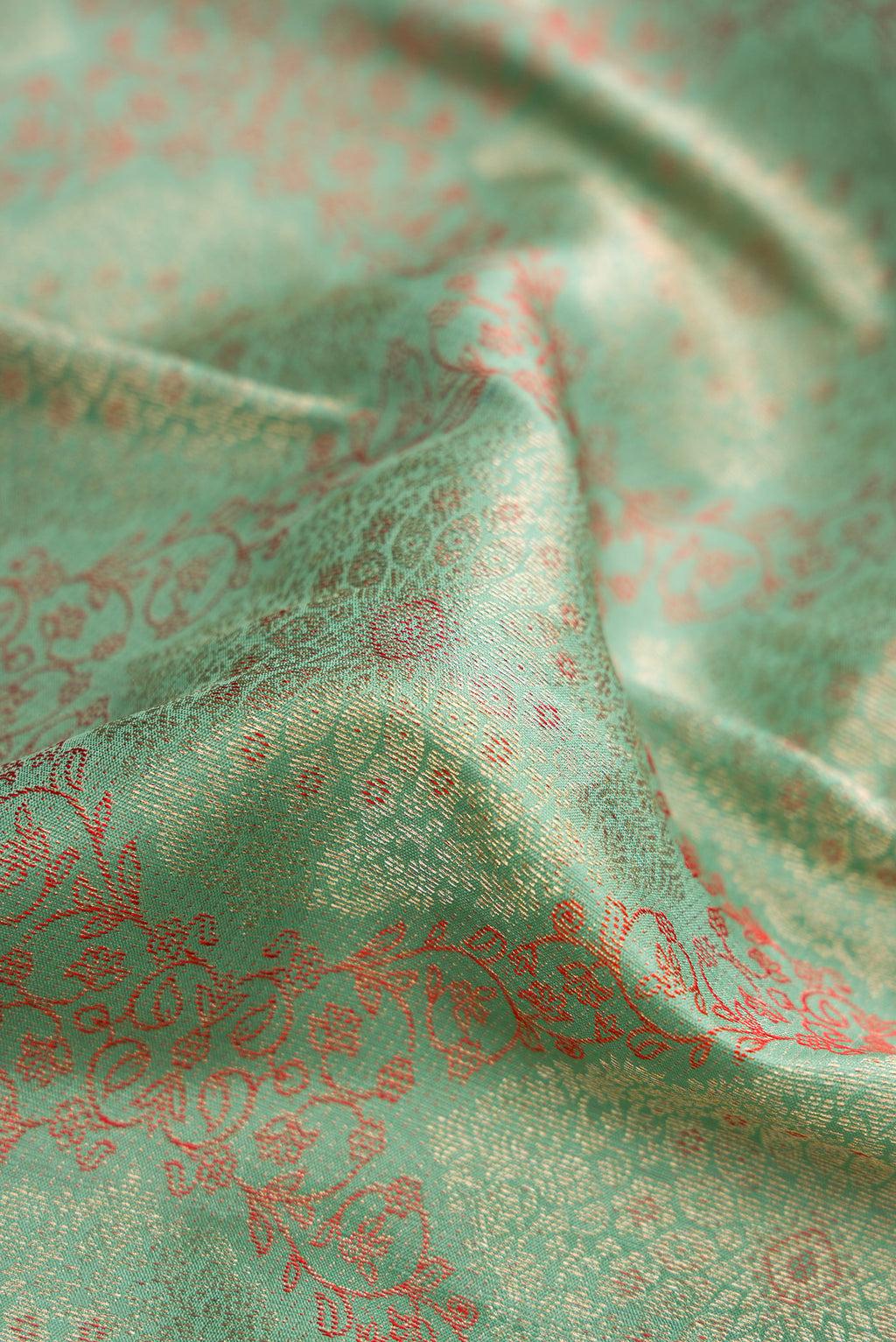 Close up of Light Green Dual Tone Kanjivaram Silk Saree with Zari Brocade on the body and Zari Border.  displaying folds