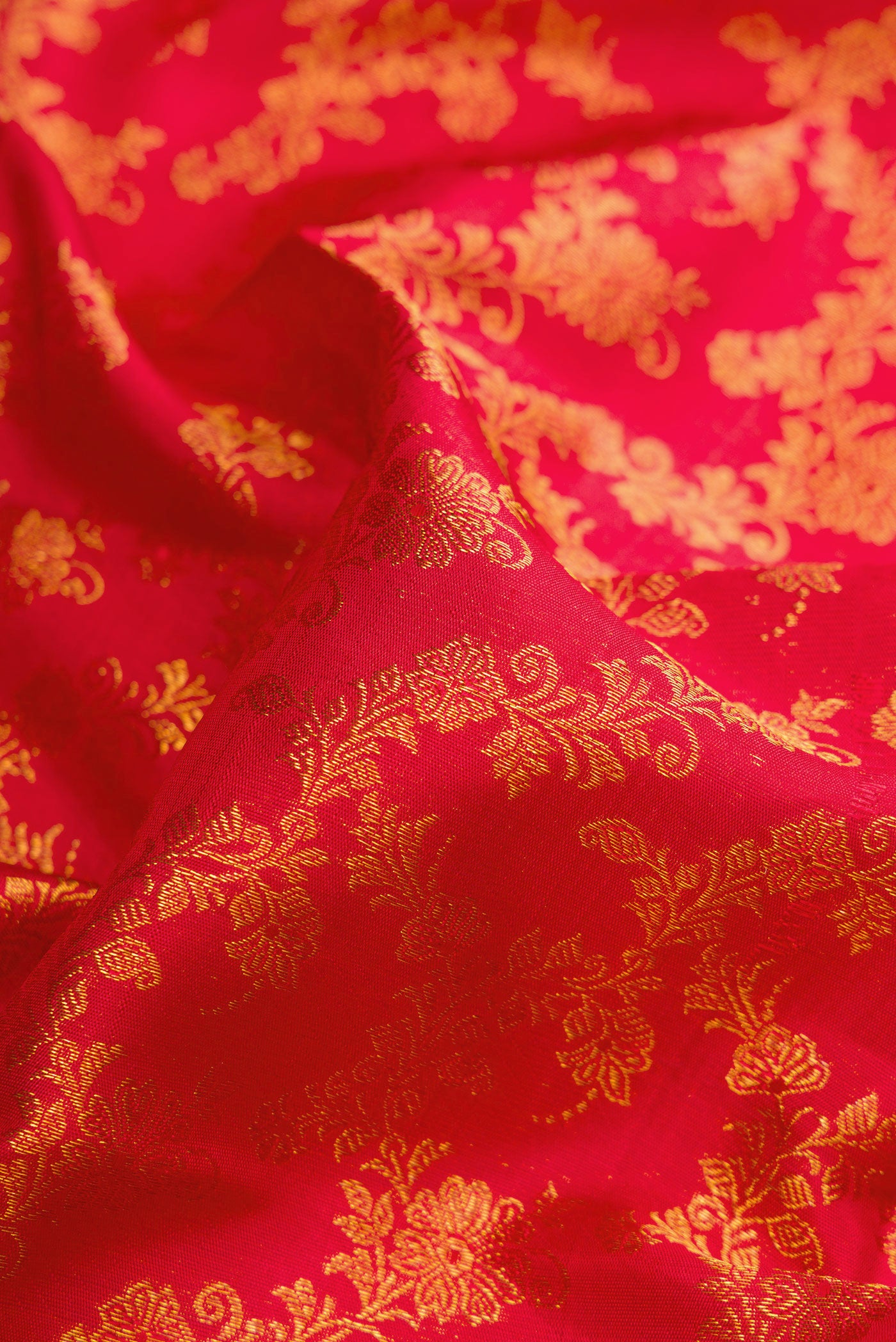 Close up of Red Dual Tone Kanjivaram Silk Saree with Zari Brocade on the body and Zari Border.  displaying folds