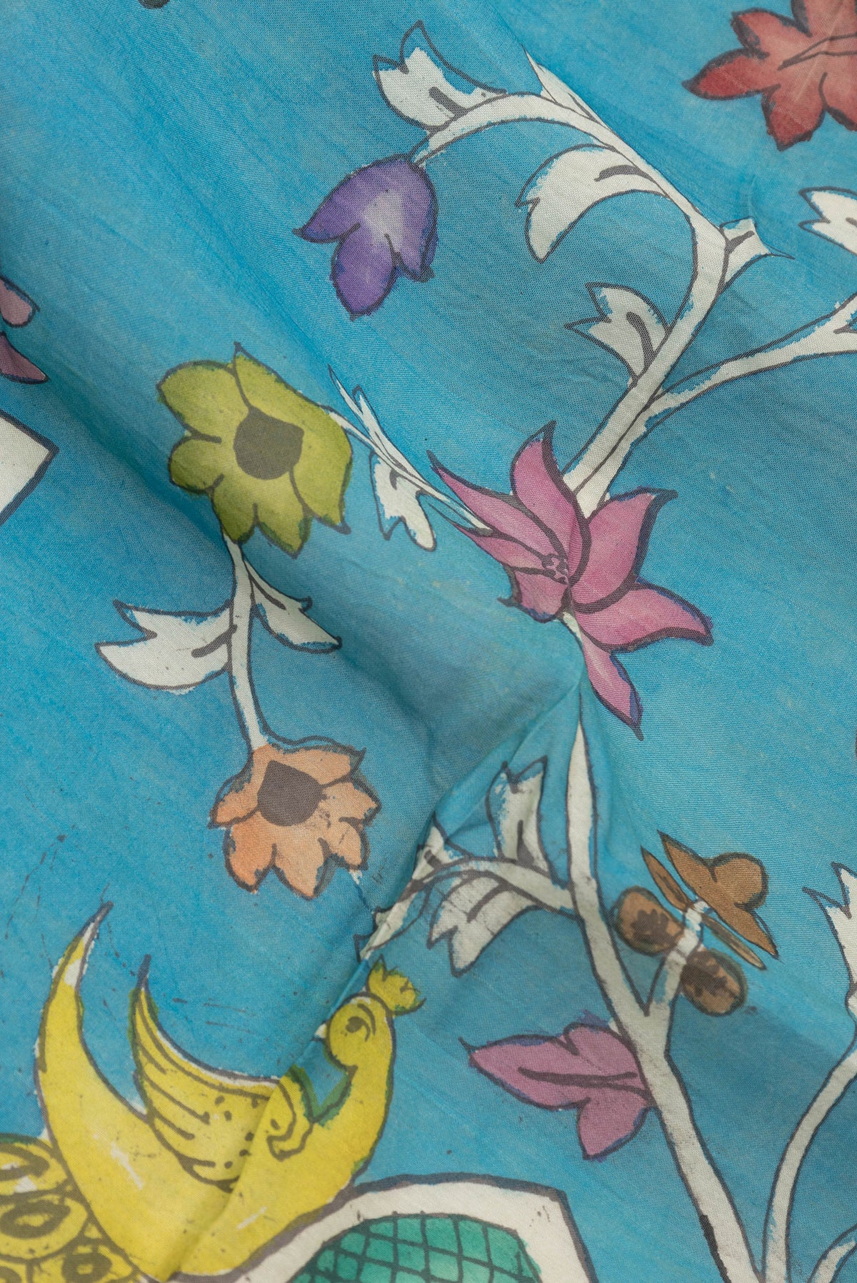 Close up of Blue Dual Tone Tussar Silk Saree with Printed design on the body and Zari Border.  displaying folds