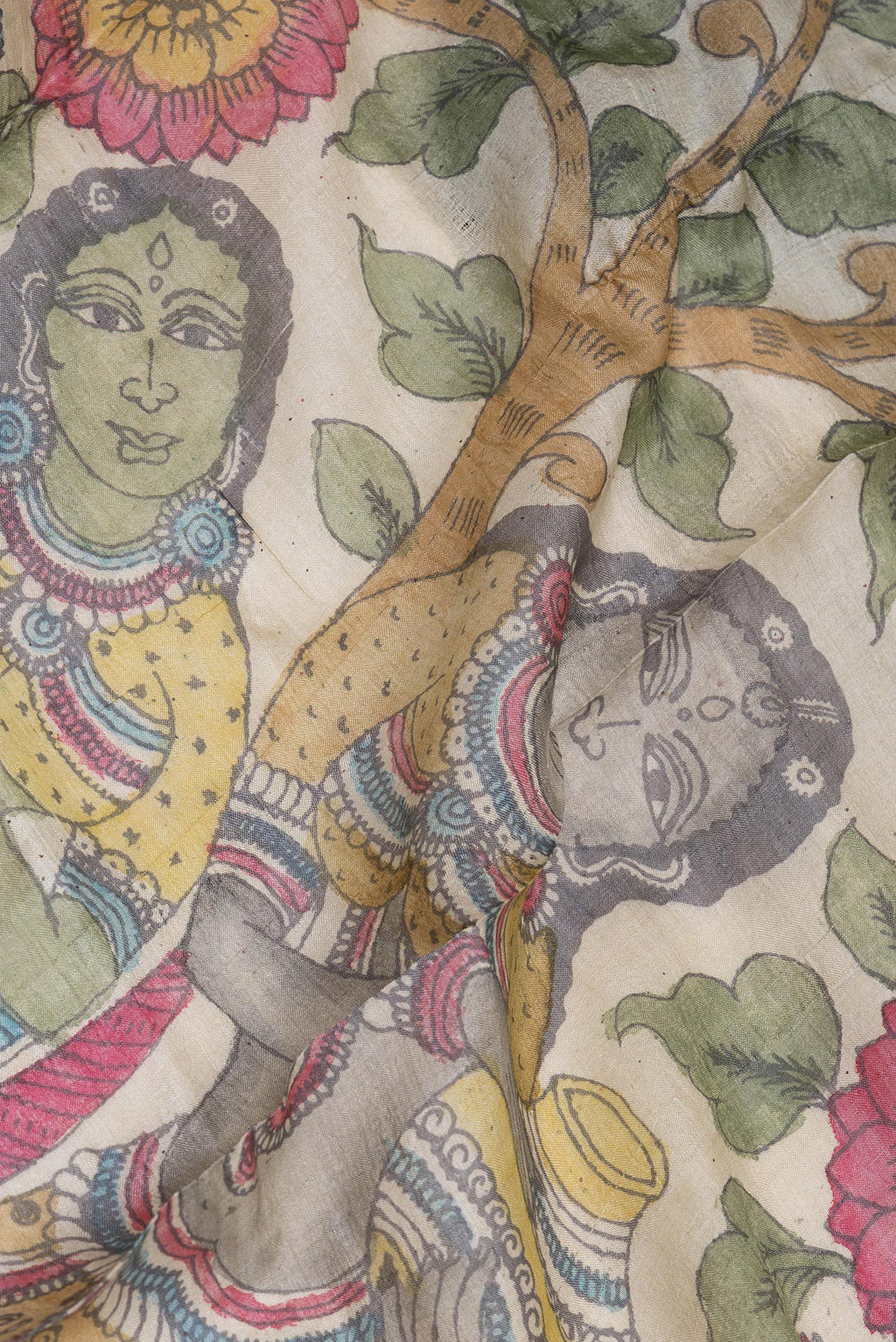 Close up of Beige Tussar Silk Saree with kalamkari Print on the body and Zari Border.  displaying folds