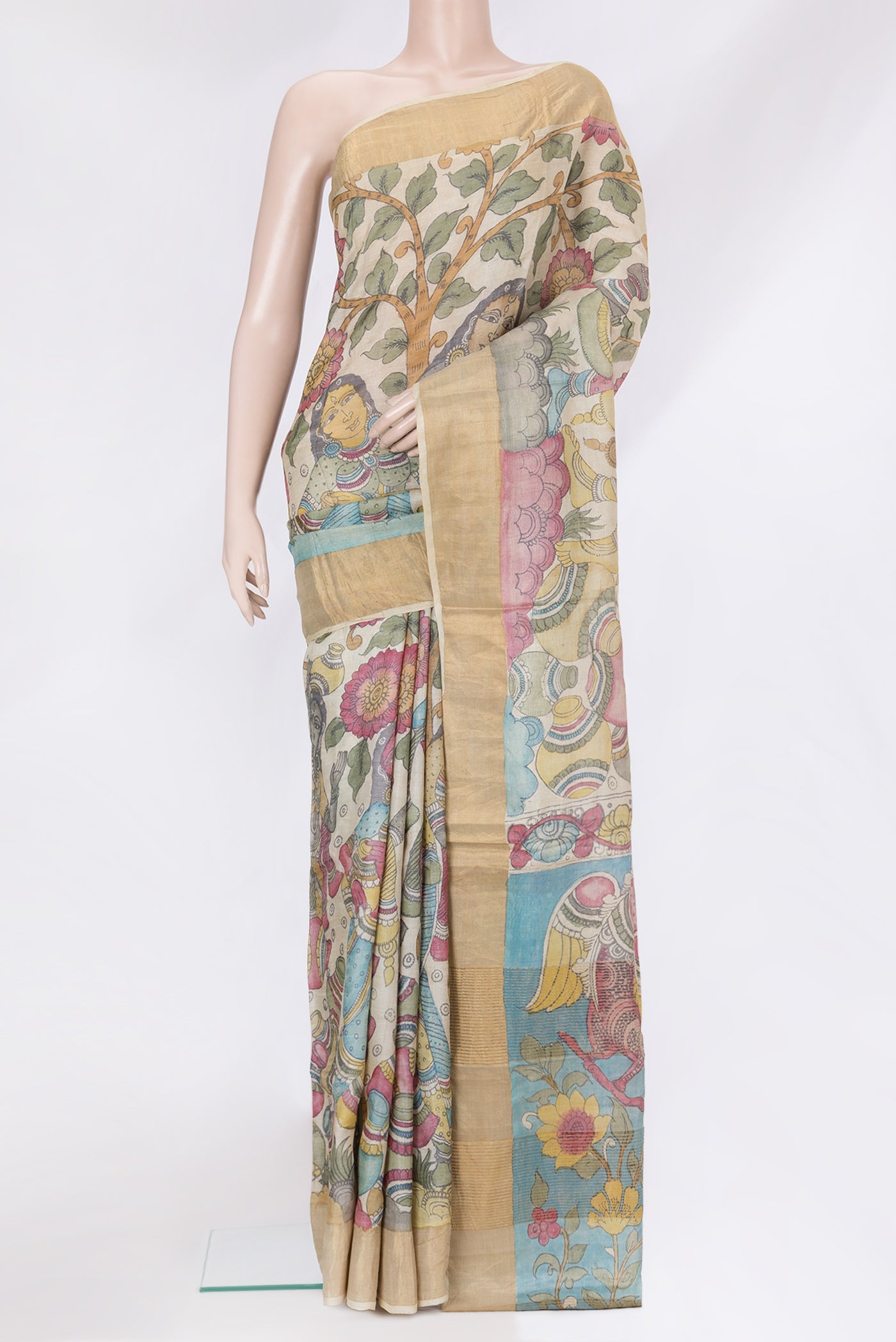 Beige Tussar Silk Saree with kalamkari Print on the body and Zari Border.  displayed on a mannequin