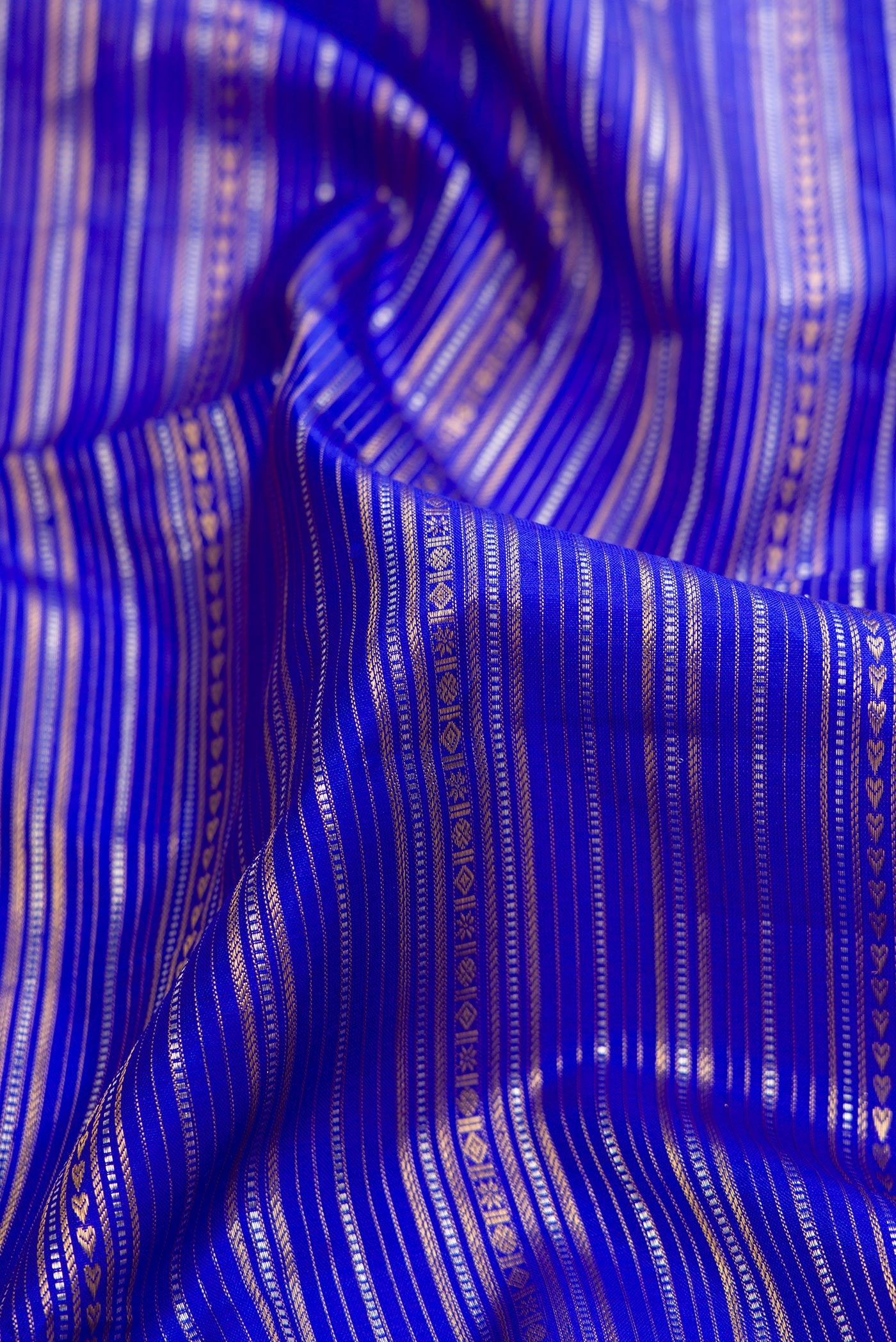 Close up of Pure Silk Pure Zari Royal Blue Dual Tone Kanchipuram Saree with Stripes on the body and Zari Border.  displaying folds