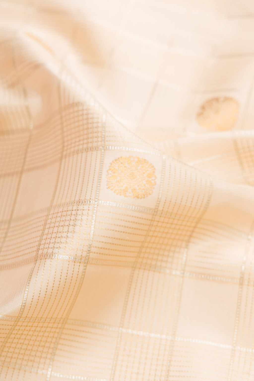 Close up of Beige Dual Tone Kanchipuram Silk Saree with Checked design on the body and Fancy Border.  displaying folds