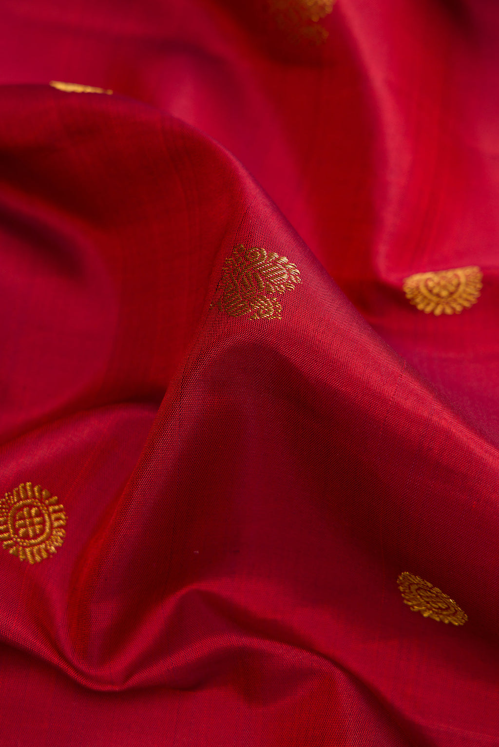 Close up of Red Dual Tone Kanjivaram Silk Saree with Zari Butta on the body and Zari Border.  displaying folds