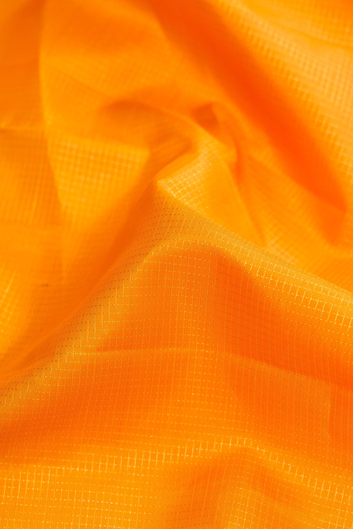 Close up of Yellow Dual Tone Kanchipuram Silk Saree with Checked design on the body and Zari Border.  displaying folds