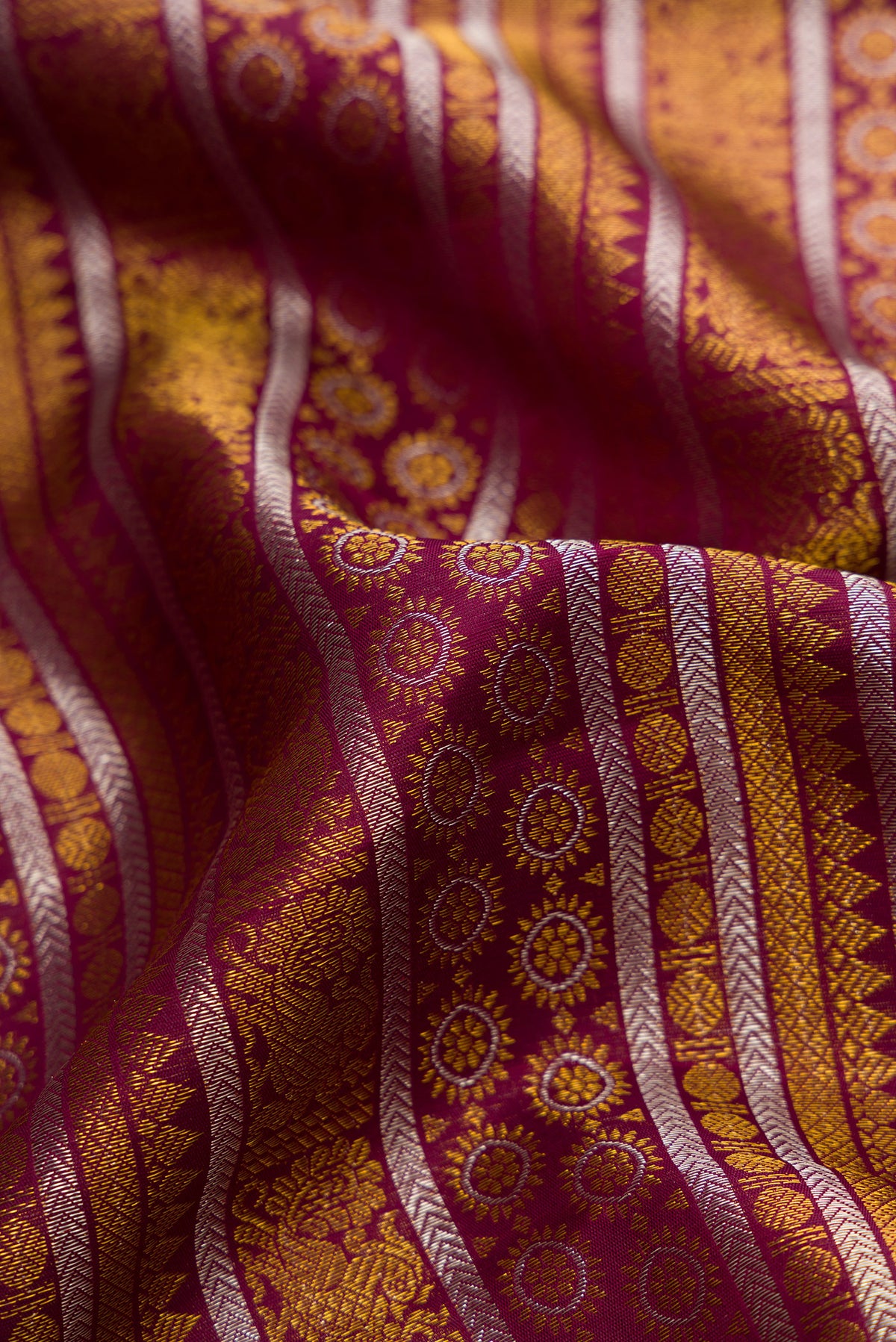 Close up of Burgundy Dual Tone Kanchipuram Silk Saree with Zari Brocade on the body and Zari Border.  displaying folds