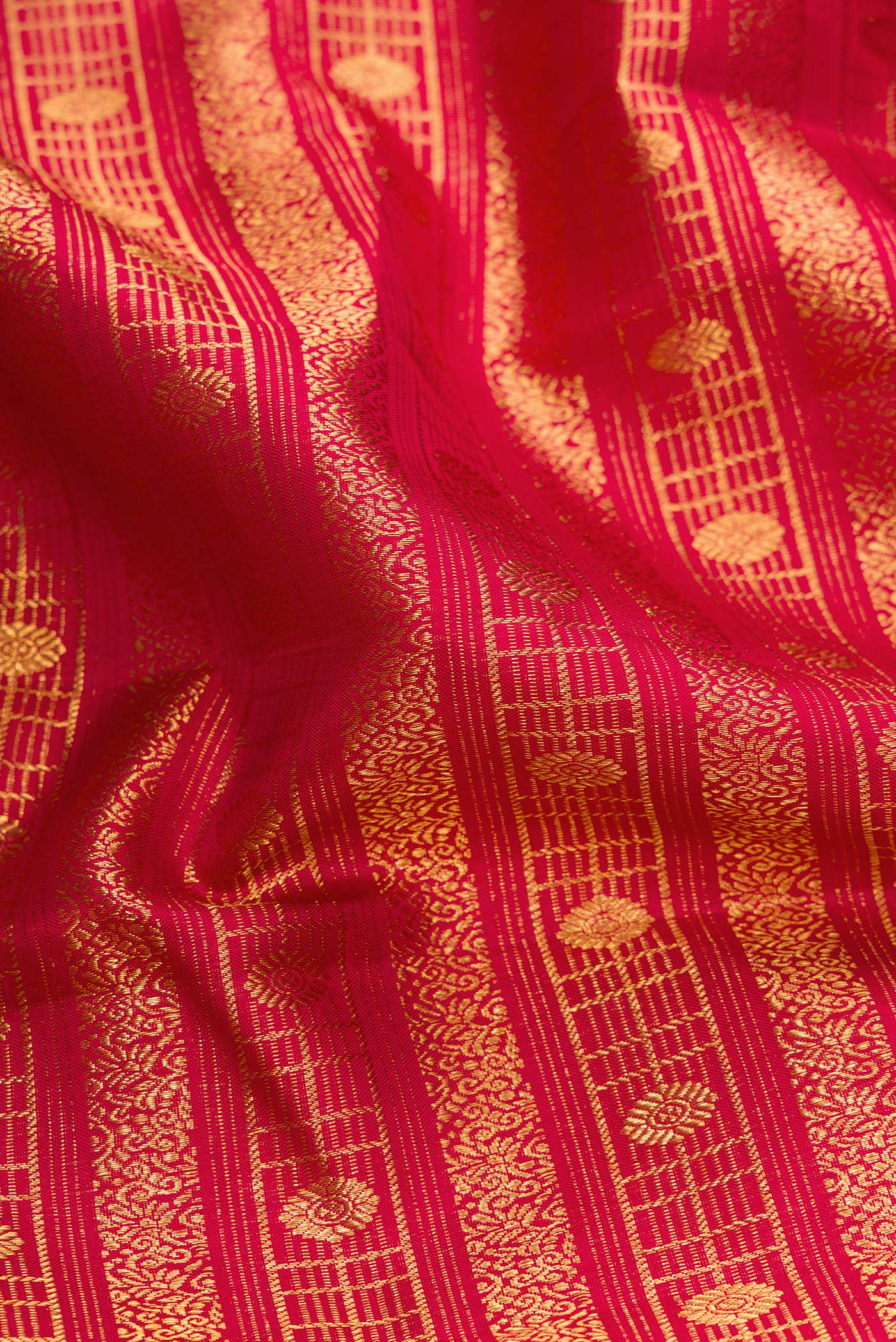 Close up of Pure Silk Pure Zari Maroon Dual Tone Kanchipuram Saree with Zari Brocade on the body and Zari Border.  displaying folds
