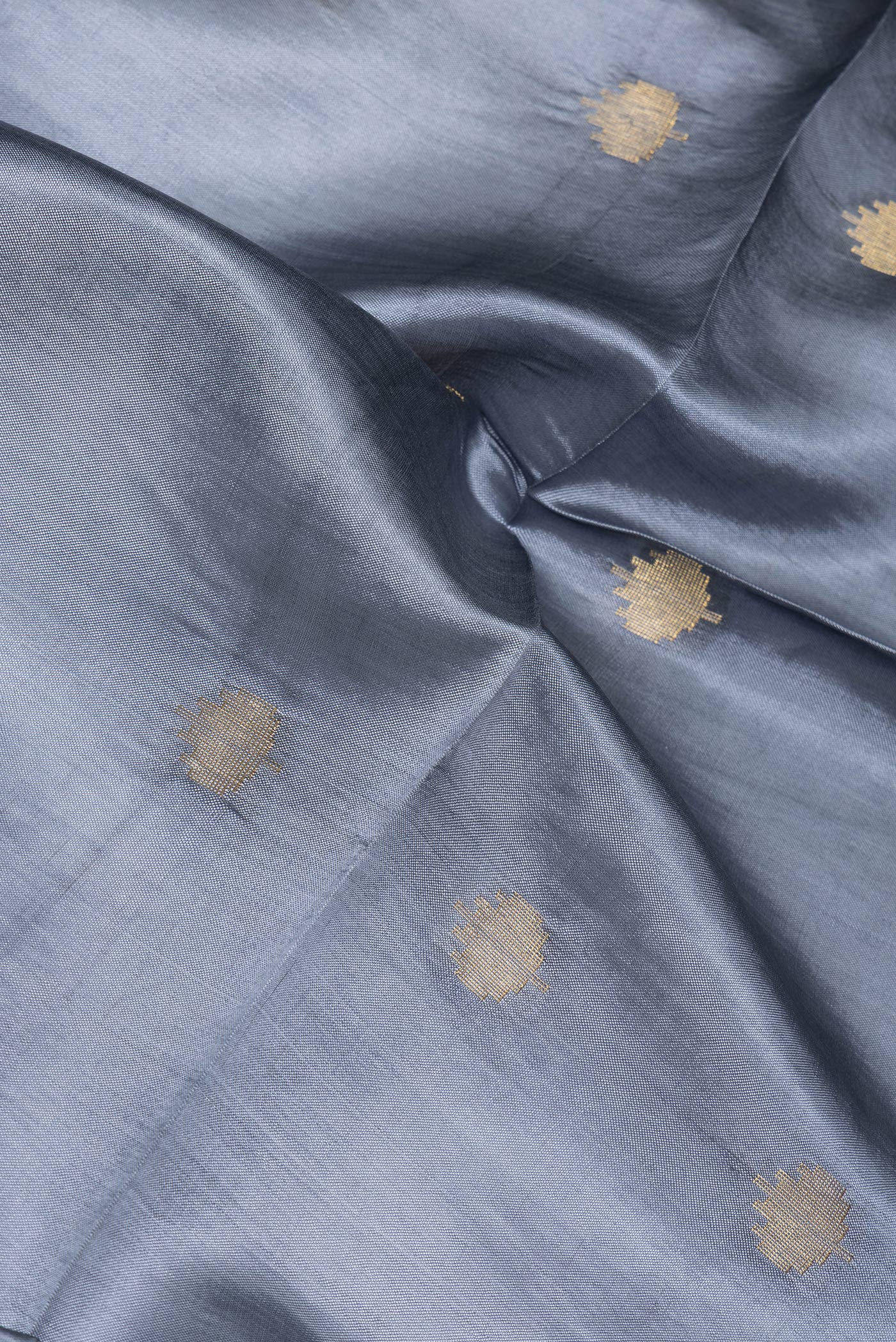 Close up of Grey Blended Tussar Silk Saree with Zari Butta on the body and Zari Border.  displaying folds