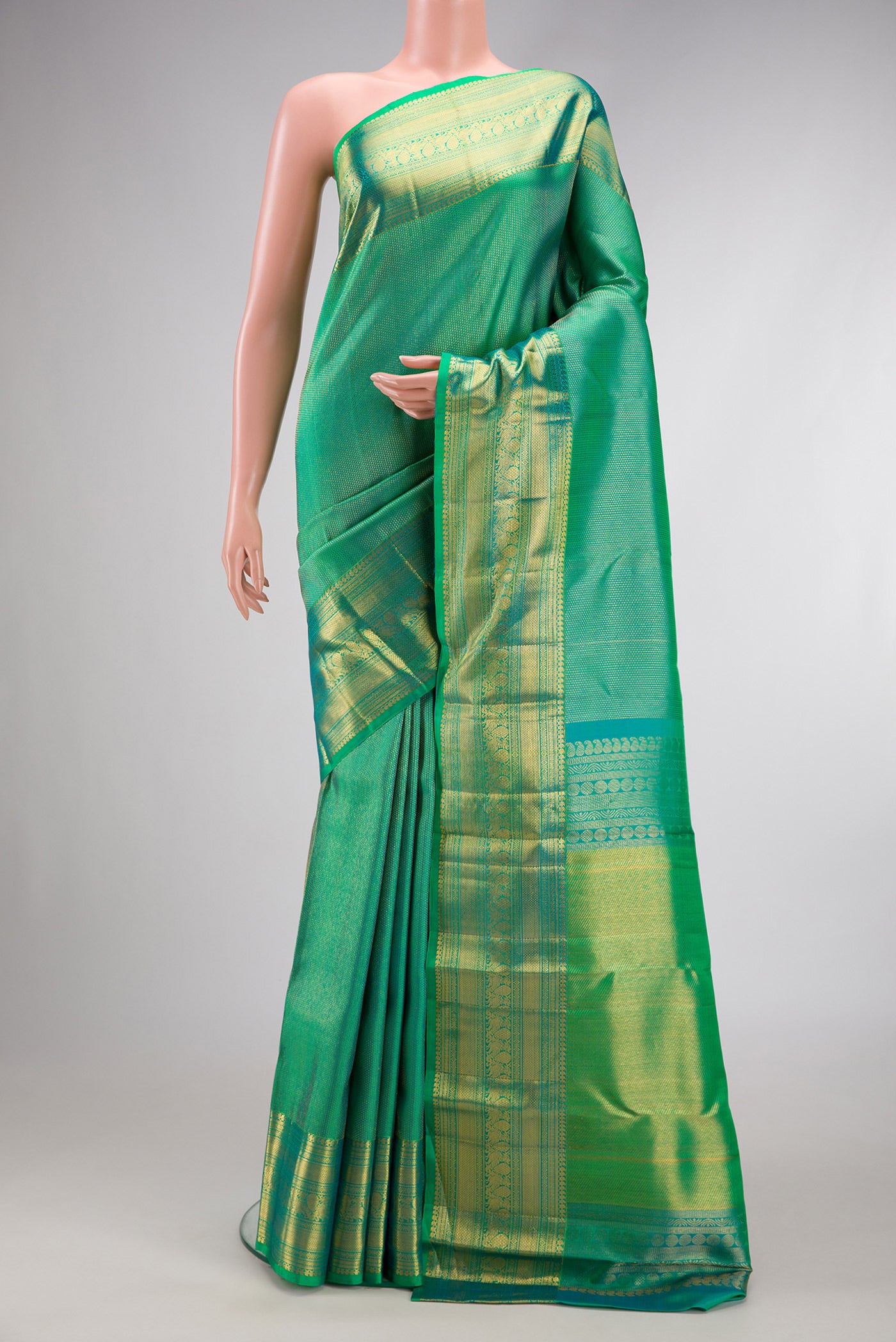 Green Dual Tone Kanchipuram Silk Saree with Zari Brocade on the body and Fancy Border.  displayed on a mannequin